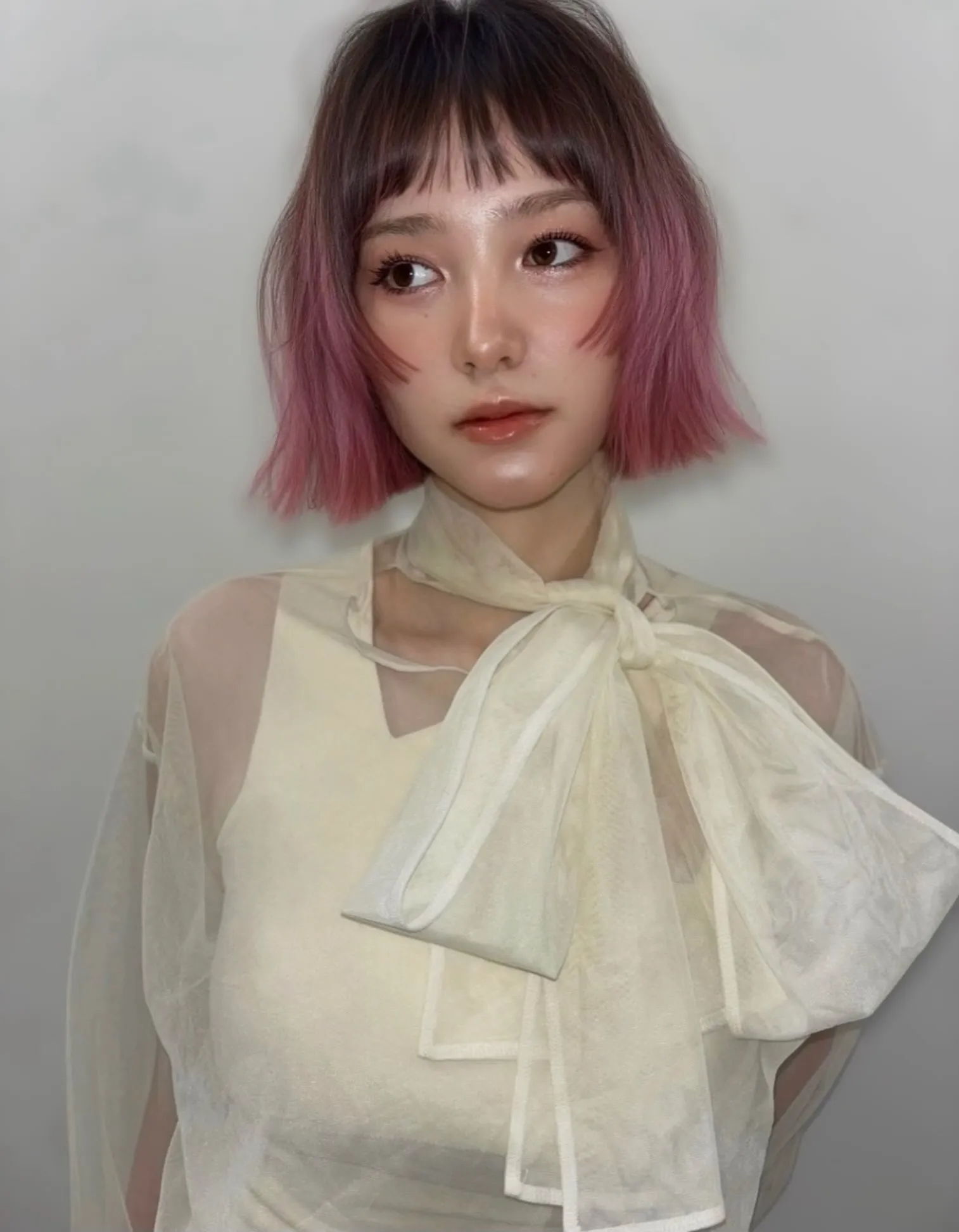 Dark-rooted bob fading into muted pink ends with short fringe