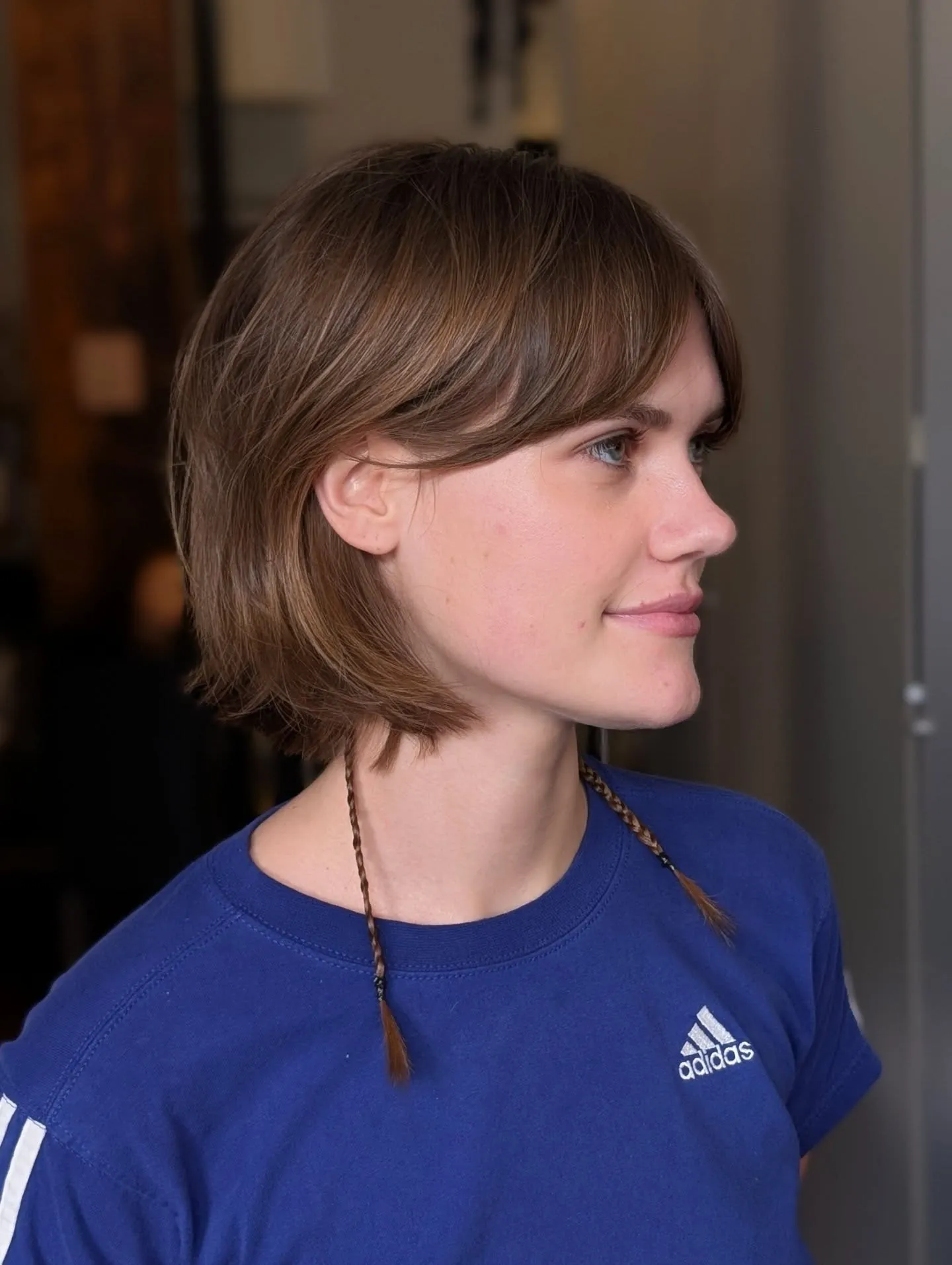Brown razor cut bob with feathered ends and long side-swept fringe