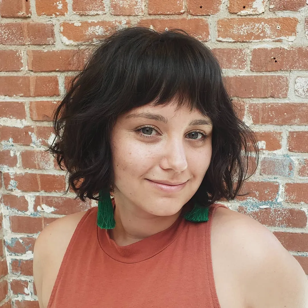 Short curly razor cut bob with soft fringe and rounded textured sides