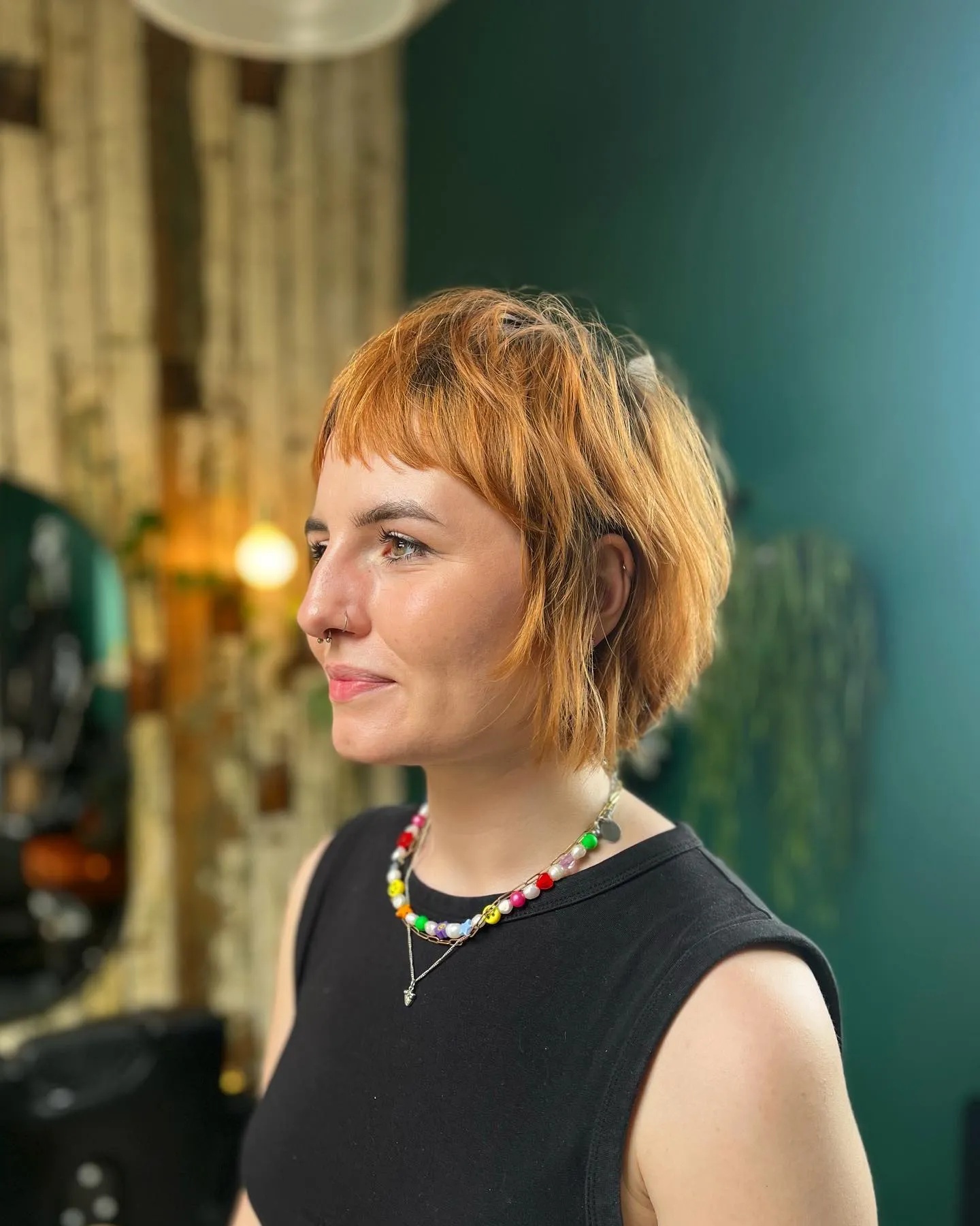 Short copper razor cut bob with choppy layers and cropped fringe