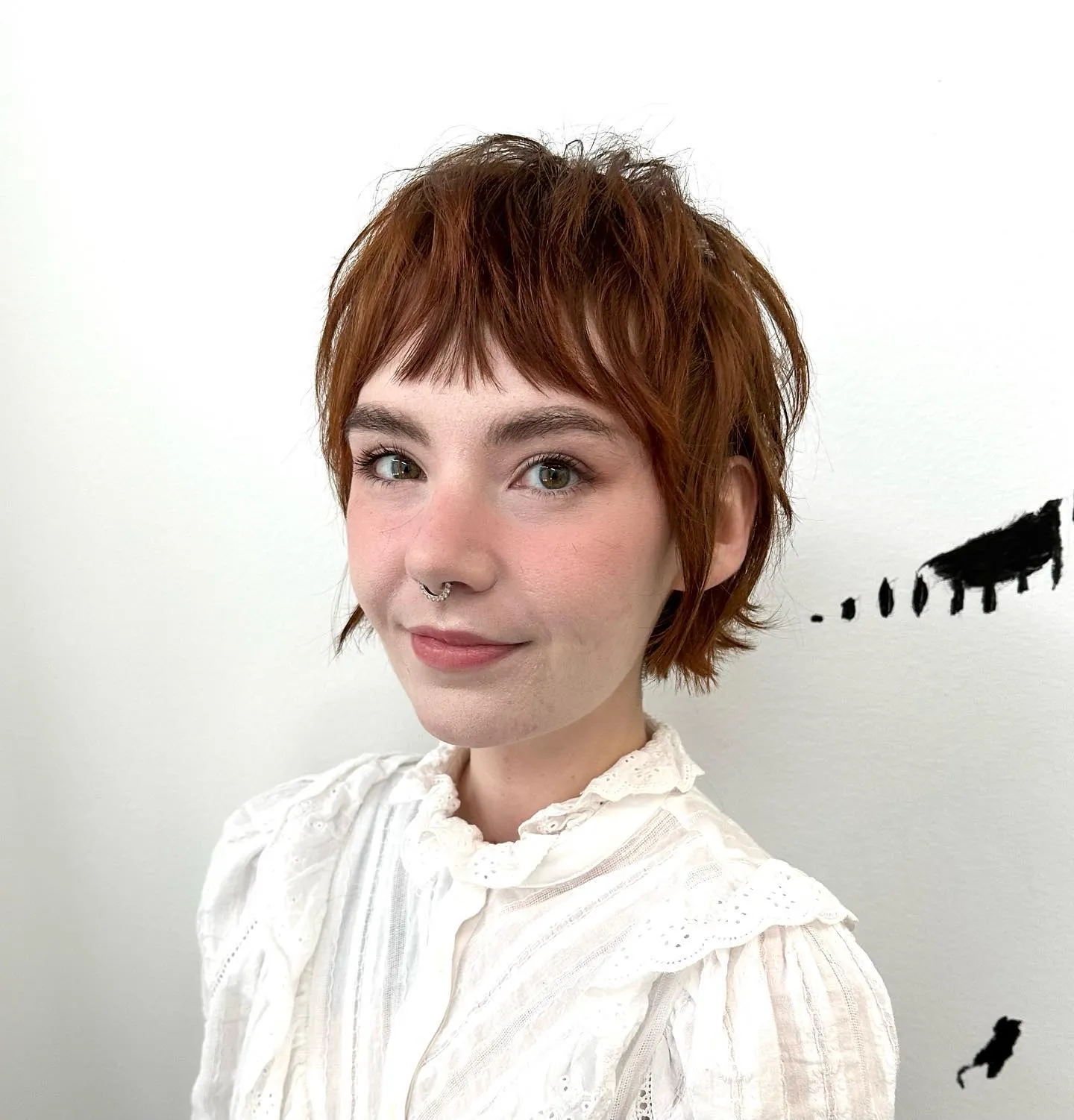 Short copper pixie bob with wispy razor cut layers and tiny fringe