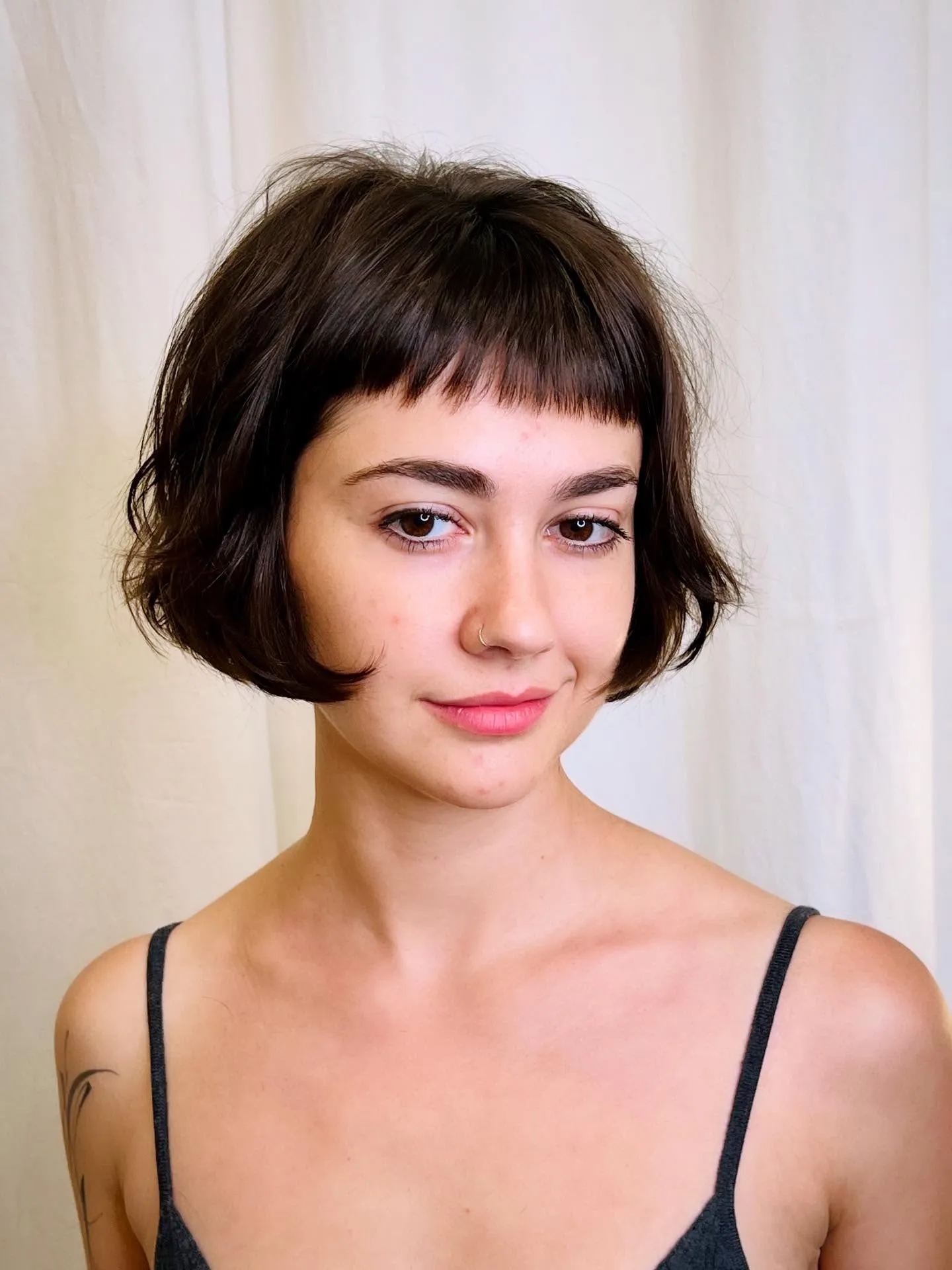 Dark razor cut bob with blunt micro fringe and curved jaw-length ends