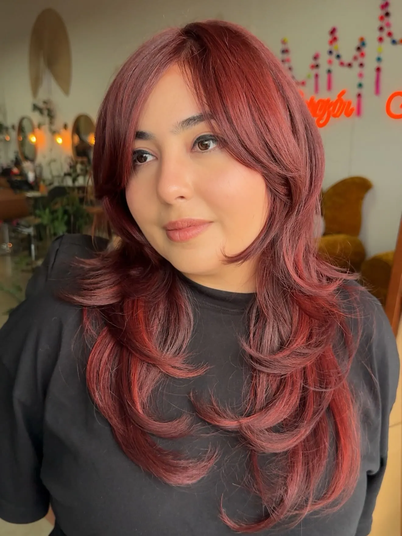 Long layered hair with soft rose-red color and curtain bangs