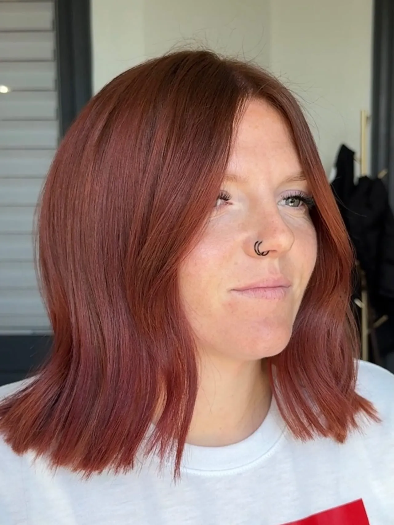 Blunt shoulder-length lob with muted auburn-red hair color