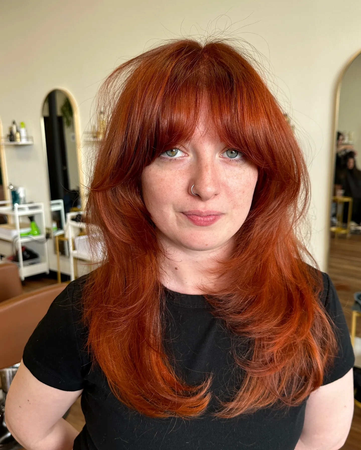 Long copper-red feathered layers with curtain bangs