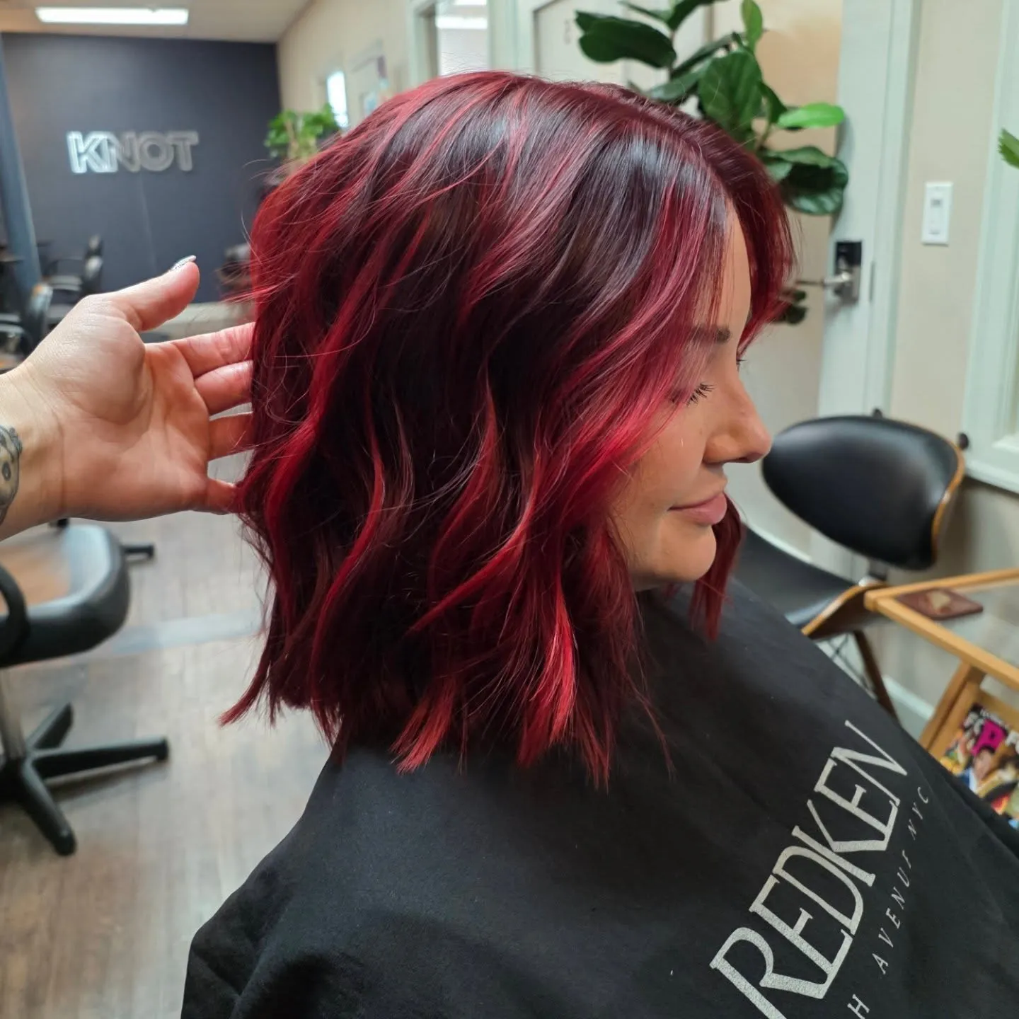 Dark shoulder-length waves with vivid red ribbon highlights