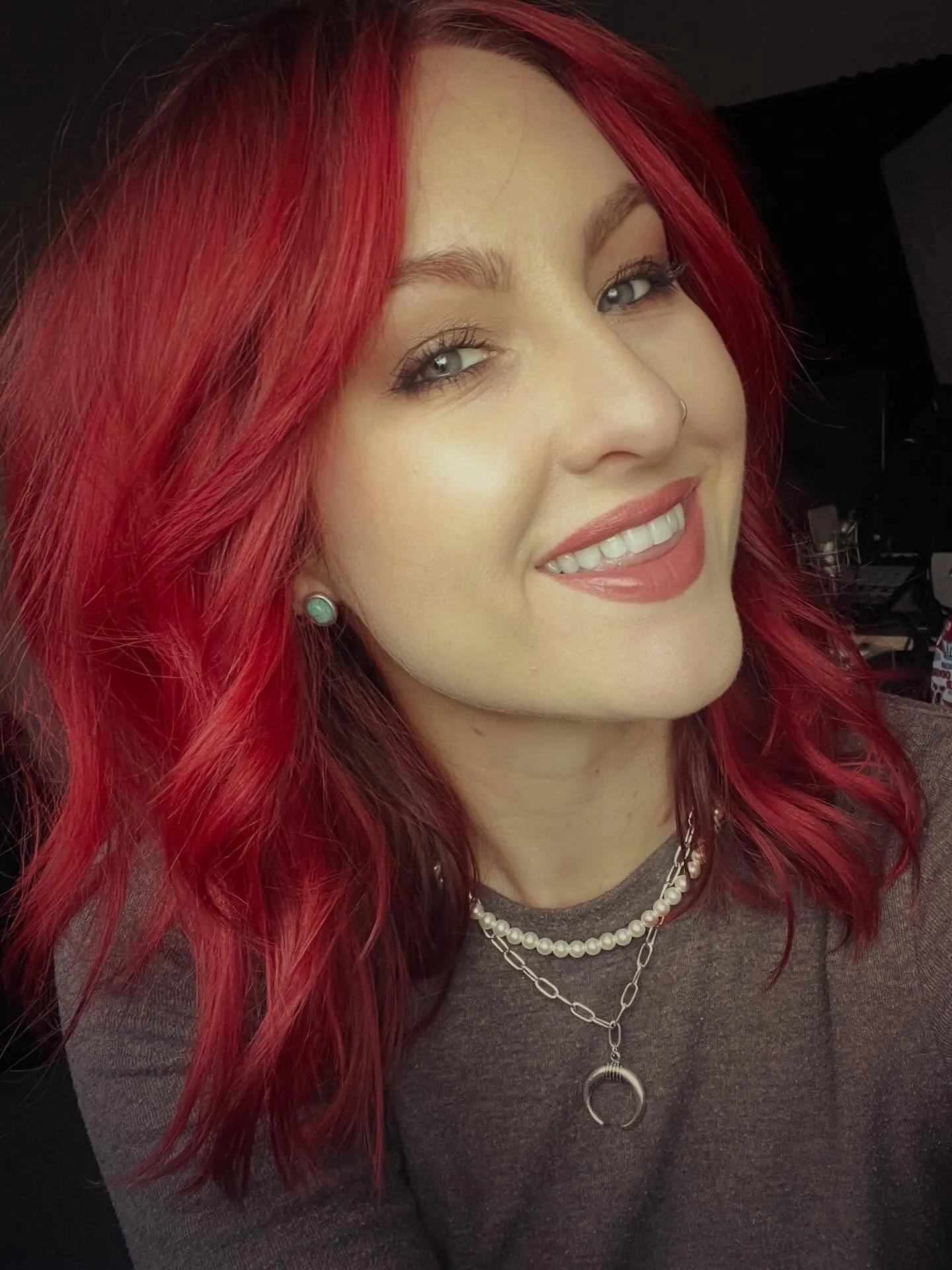 Shoulder-length scarlet-red wavy lob with dark roots