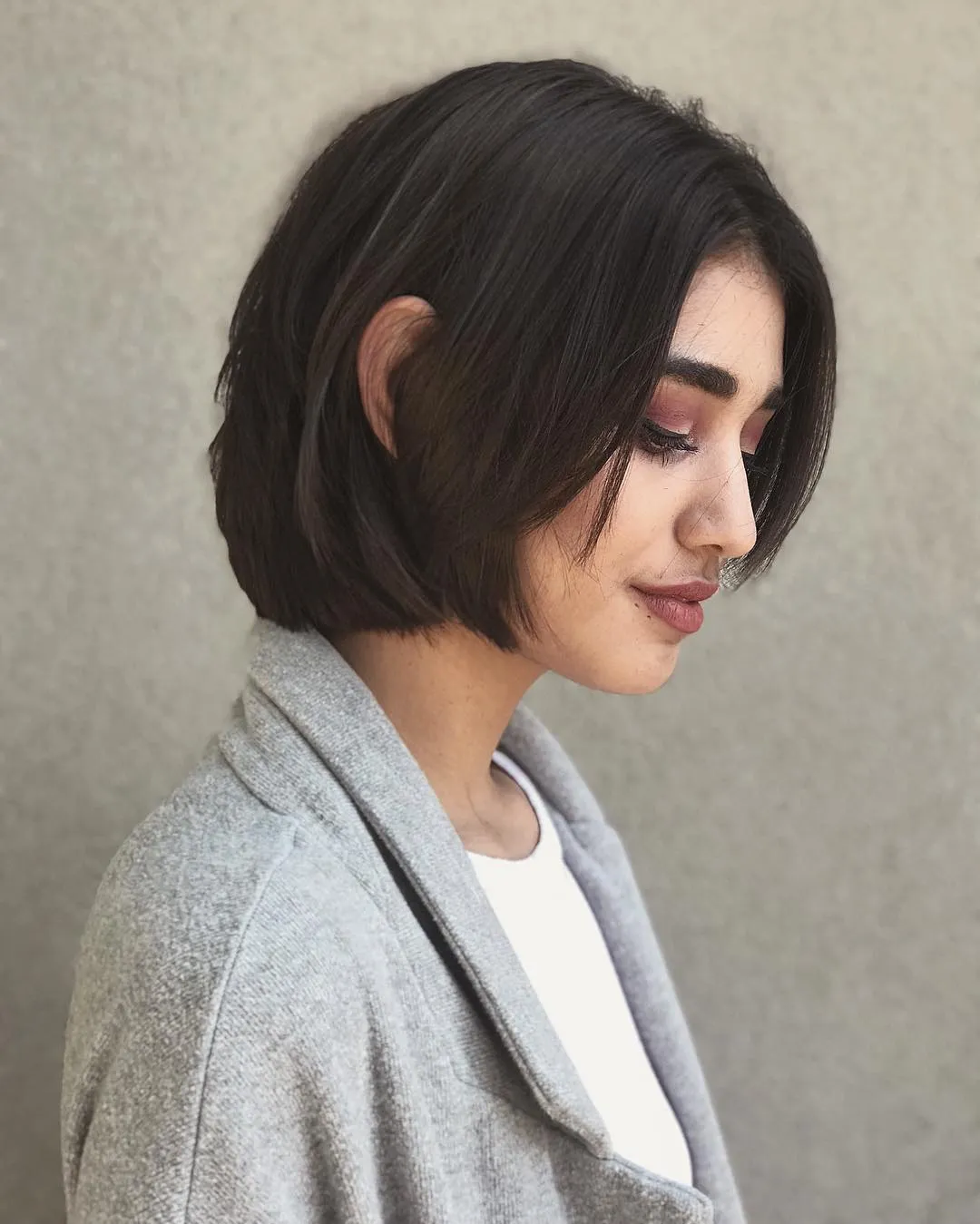 Sleek rounded bob with one side tucked behind the ear