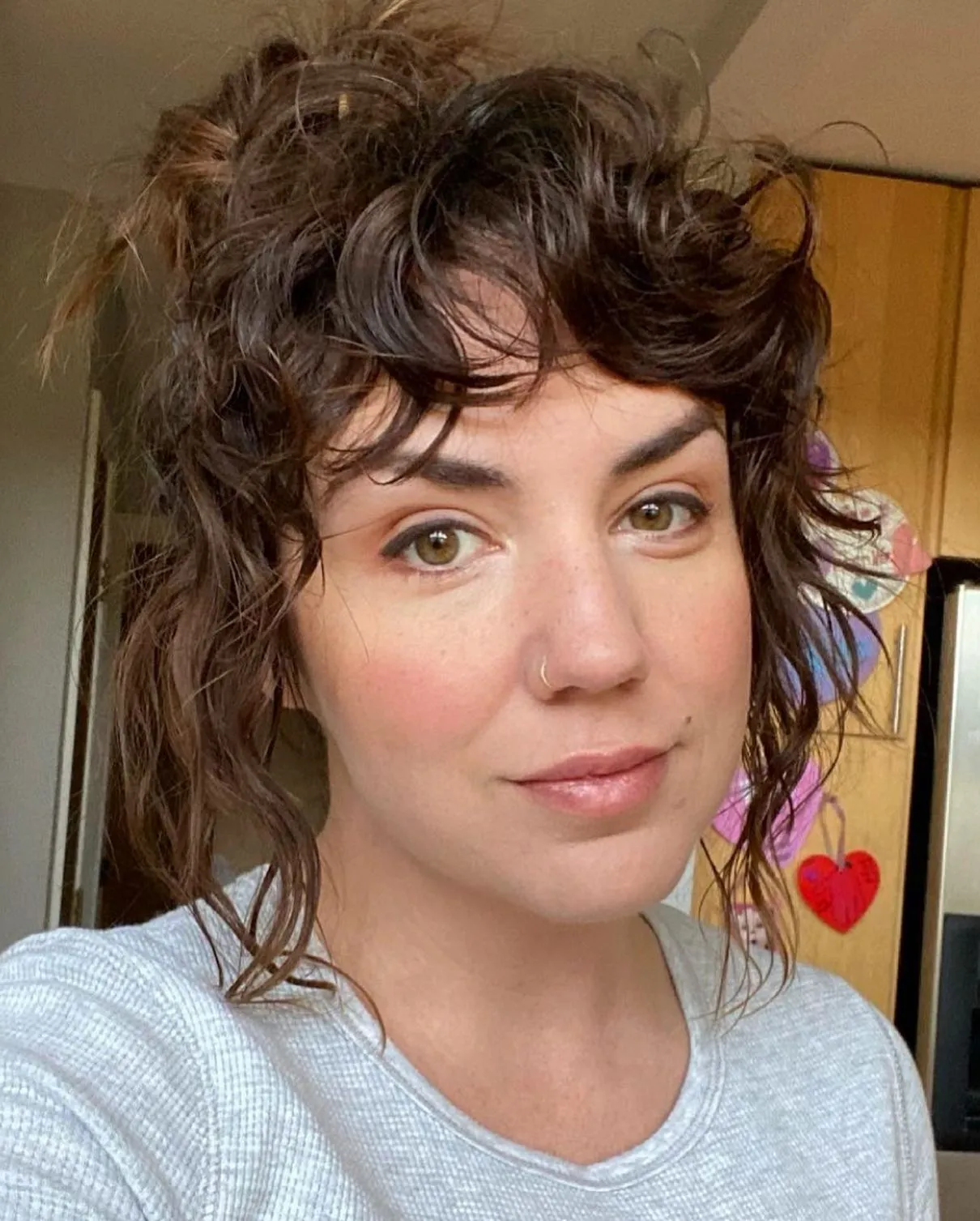 Curly shag styled in a loose updo with short fringe and face-framing tendrils