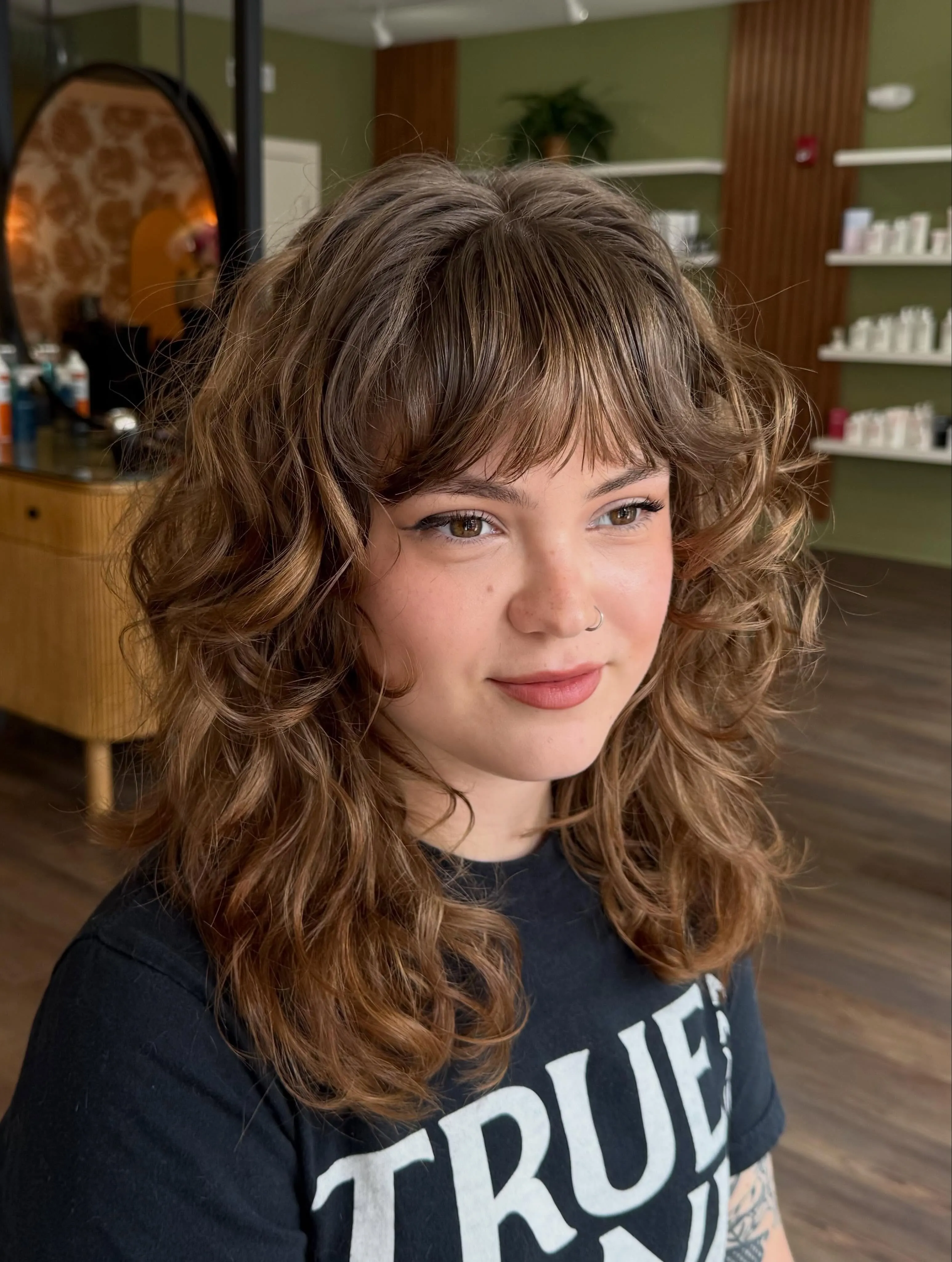 Curly shoulder-length shag with rounded fringe and layered volume