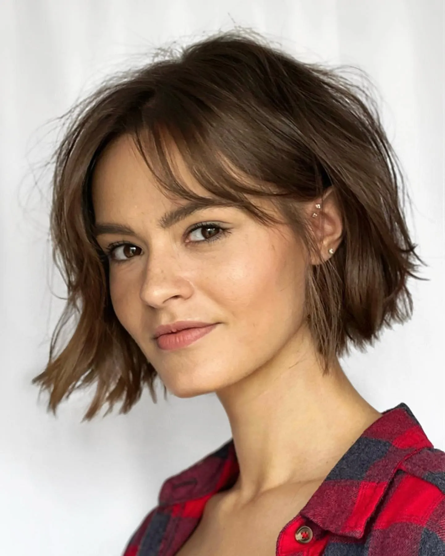 Tousled short bob with wispy curtain bangs and lightly flicked ends