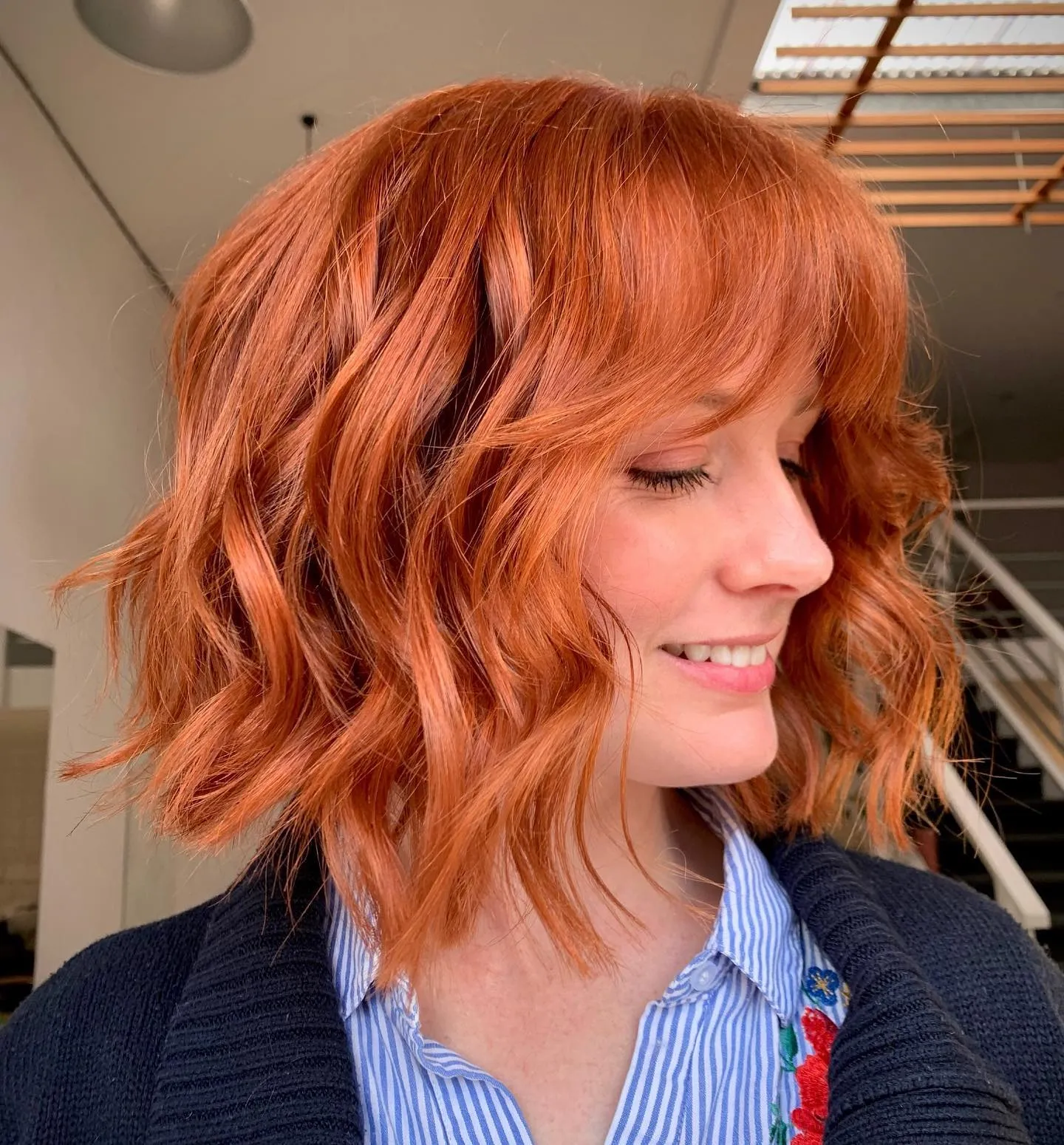 Curly short bob with full curtain bangs and defined layered waves