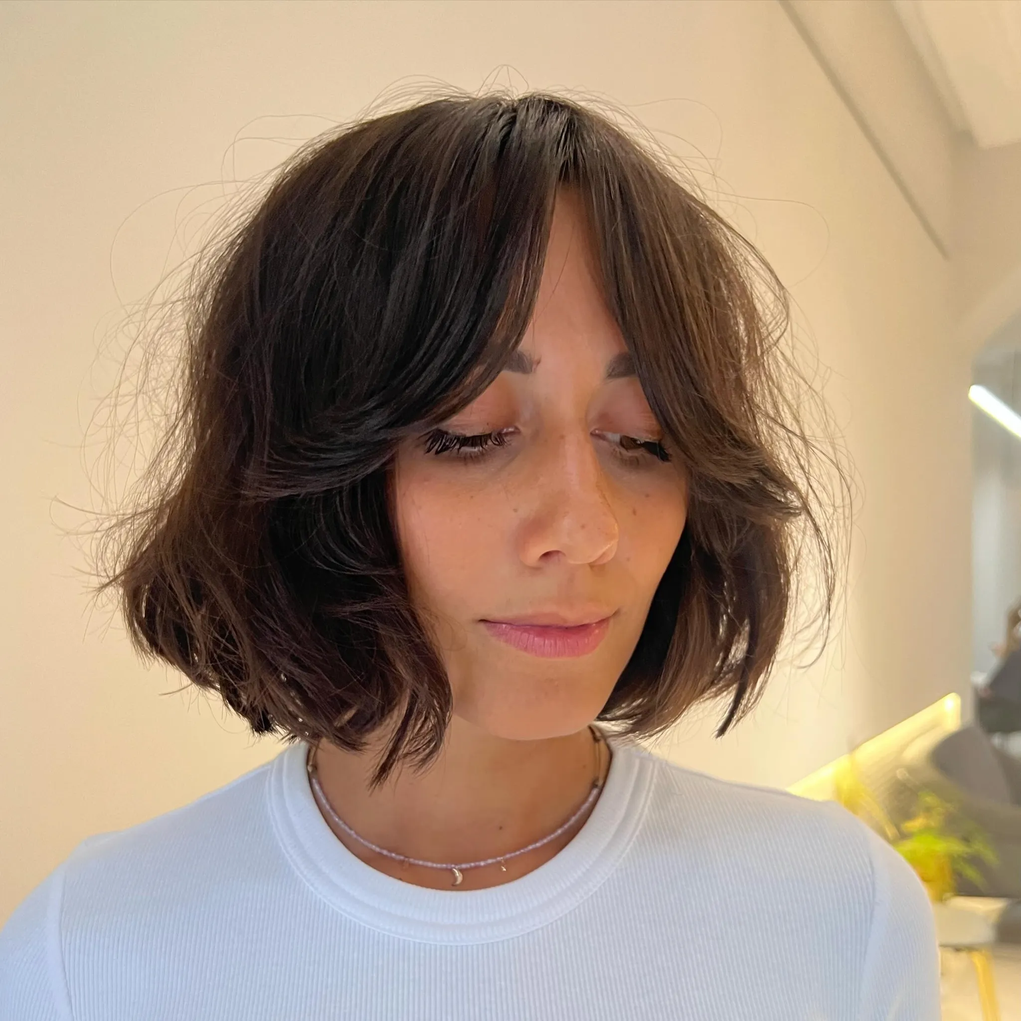 Shaggy short bob with layered curtain bangs and tousled wavy ends