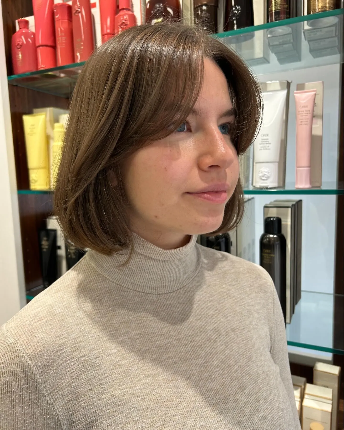 Smooth rounded short bob with long curtain bangs and softly curved jaw-length ends