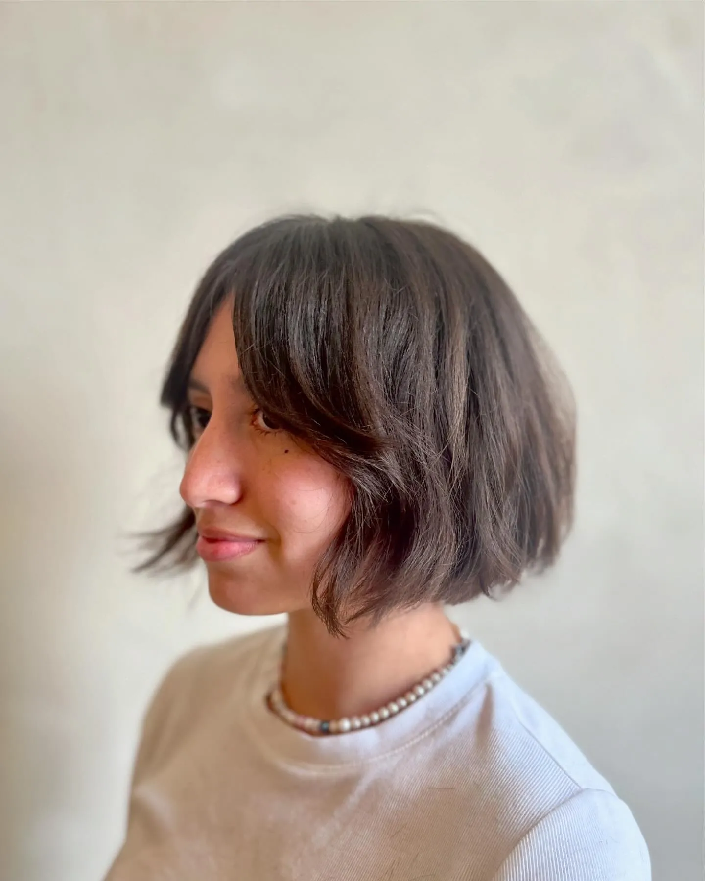 Rounded chin-length bob with long curtain bangs and smooth curved ends
