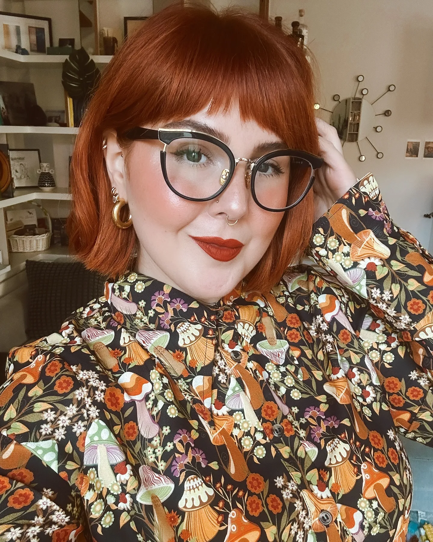 Copper blunt bob with full fringe and oversized black glasses