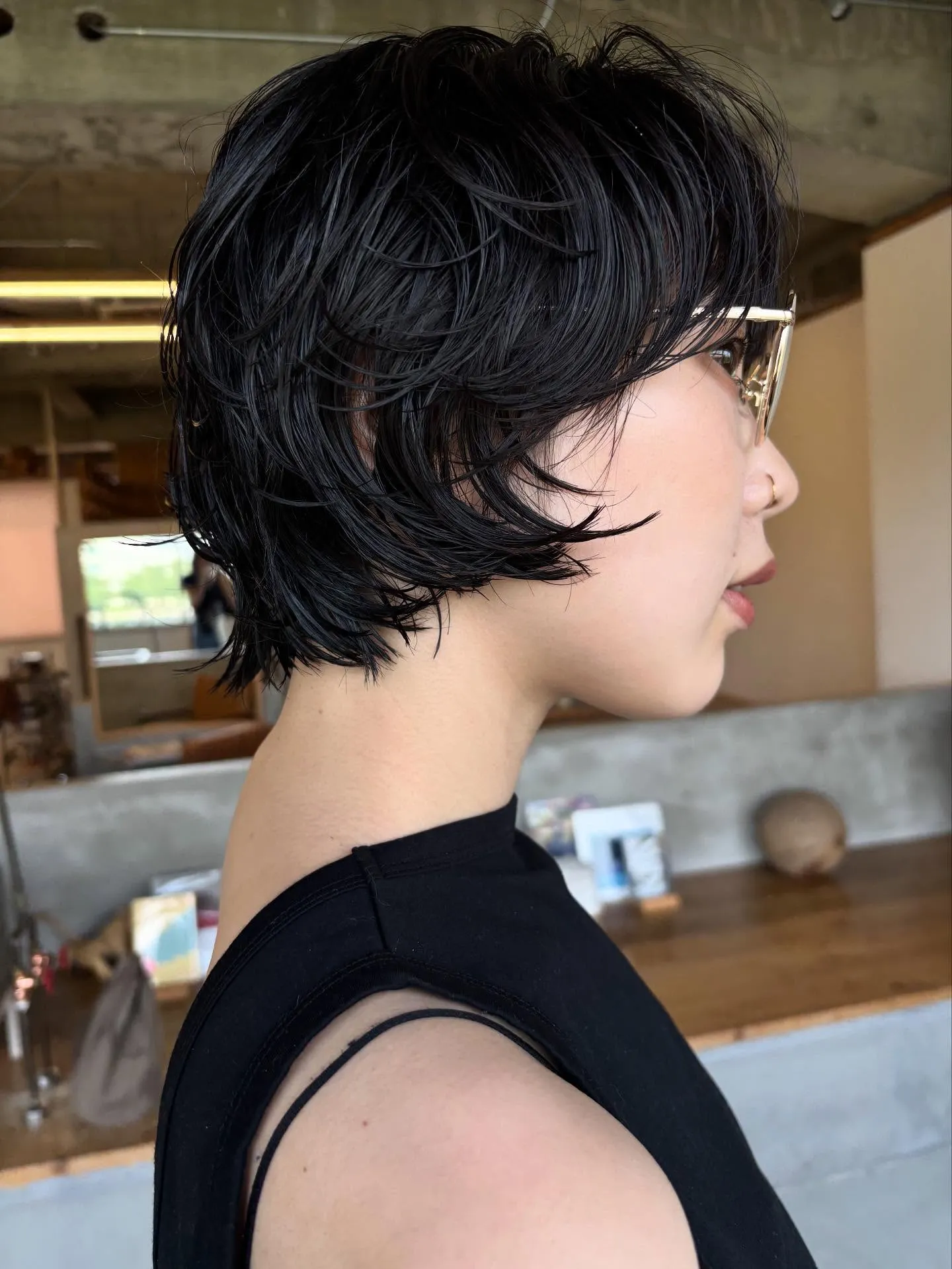 Feathered black short crop with side fringe and clear glasses