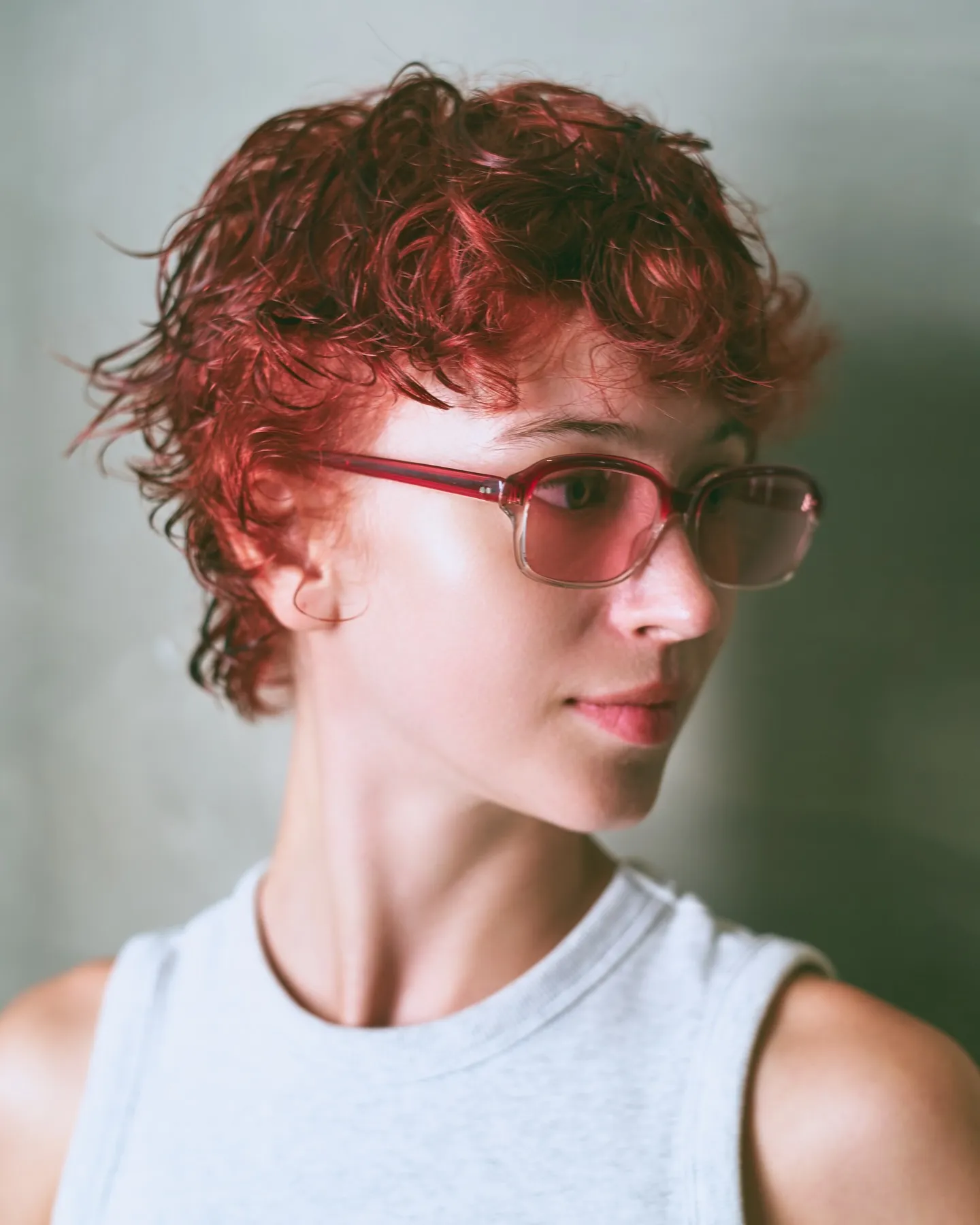 Short curly red crop with soft fringe and red rectangular glasses