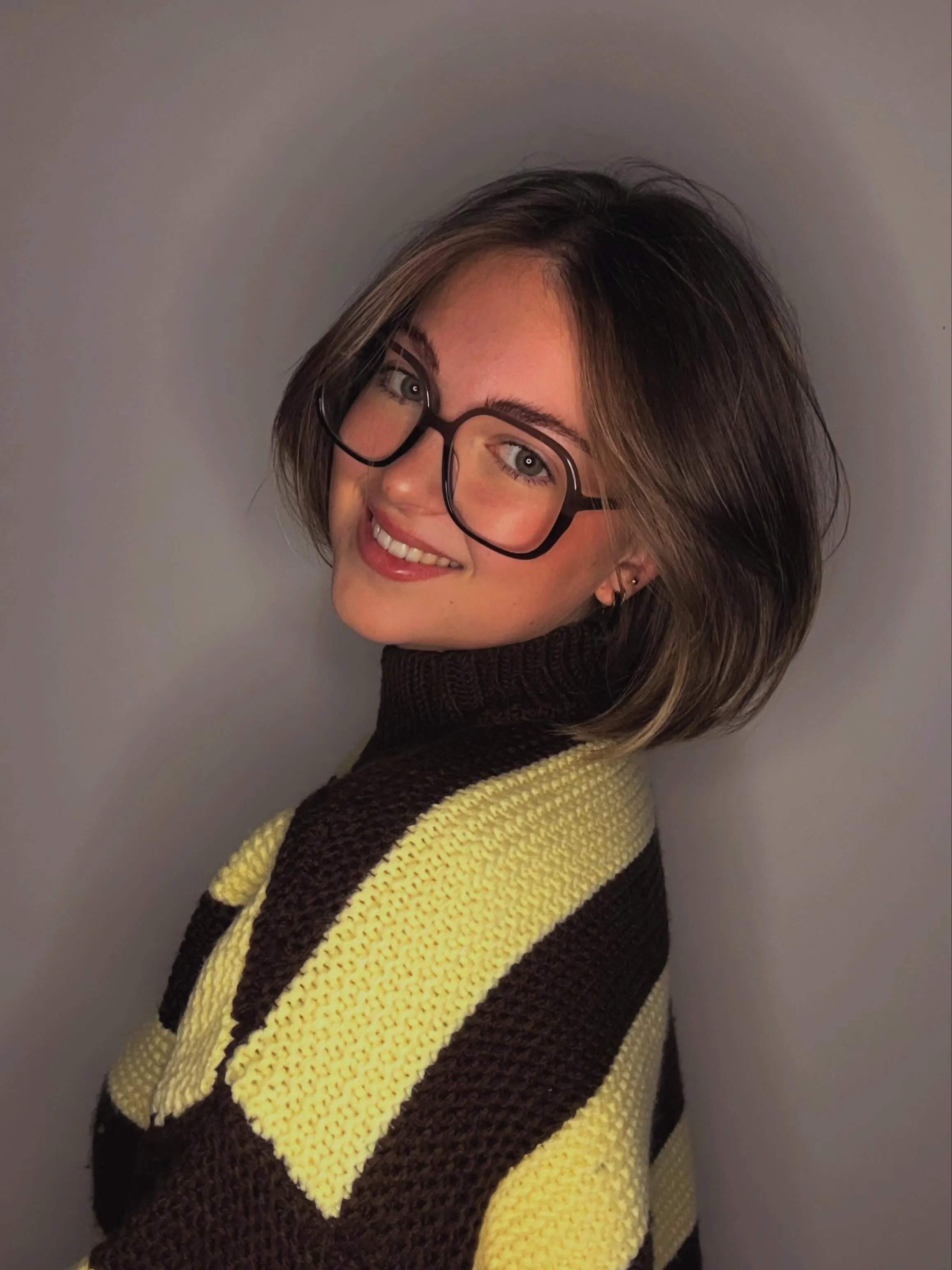 Sleek dark bob tucked behind the ears with black glasses