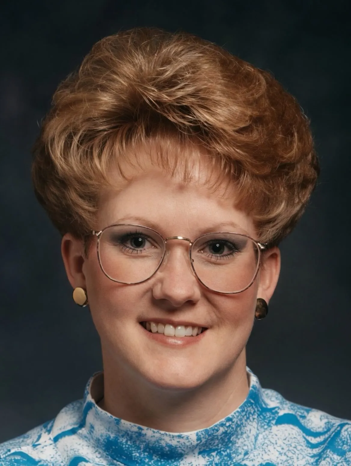 Rounded short crop with baby fringe and thin metal glasses