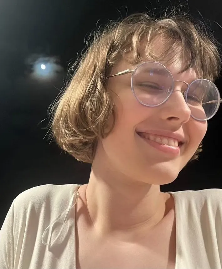 Wavy micro bob with wispy fringe and oversized clear glasses