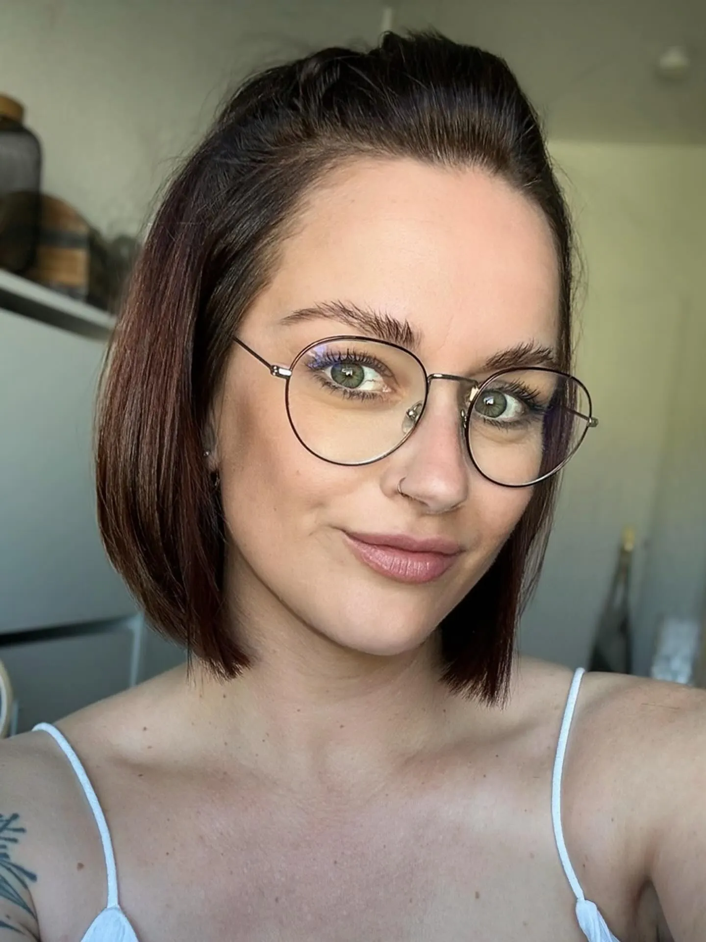 Sleek dark side-parted bob with thin round glasses