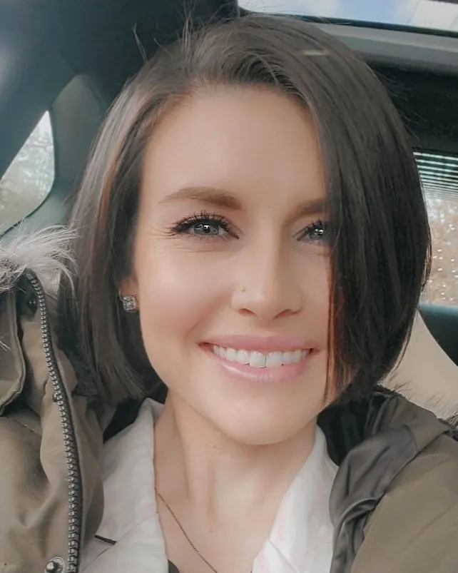 Short dark bob with a deep side part and tucked side