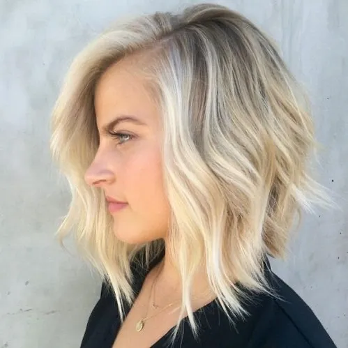 Blonde wavy angled bob with deep side part and lifted crown