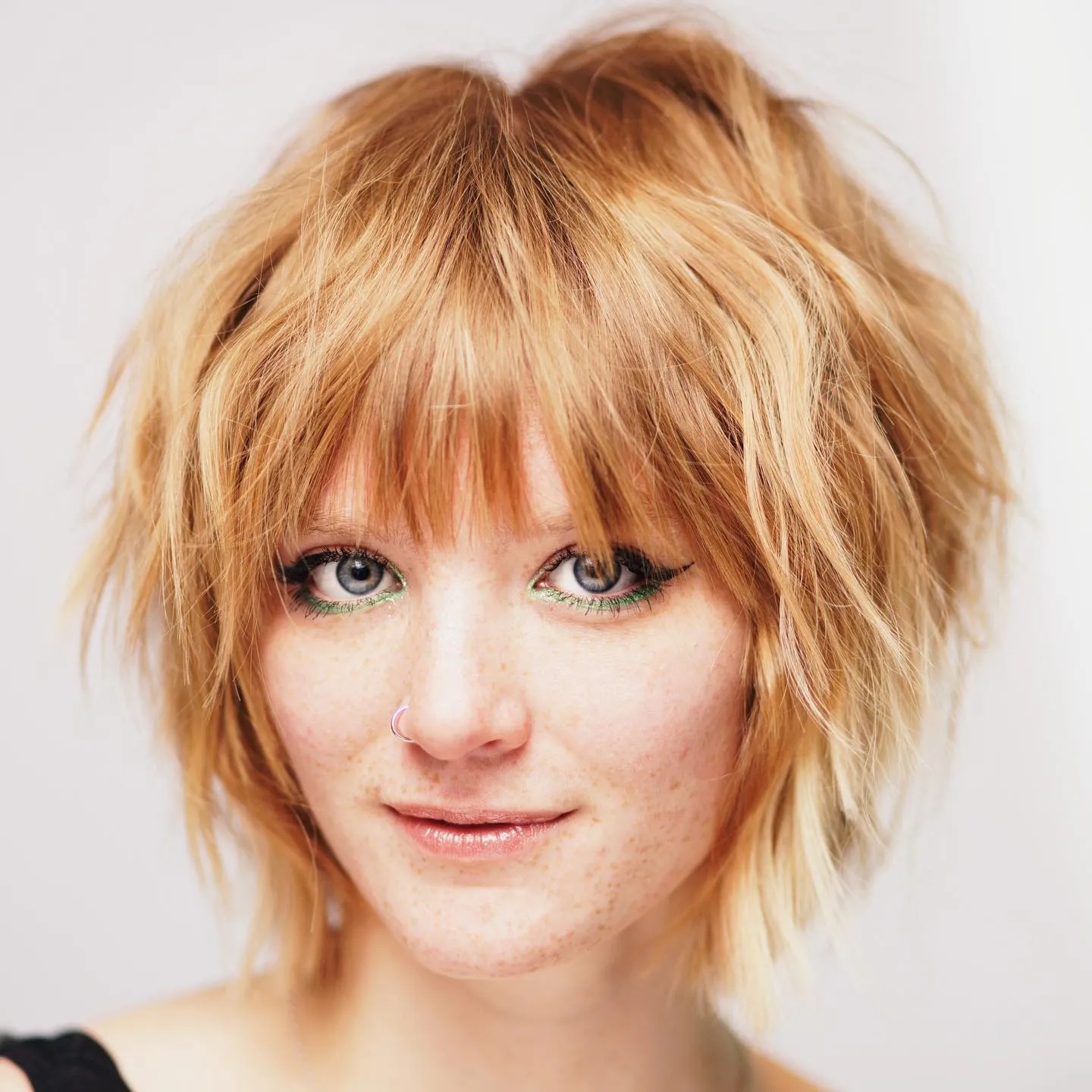 Feathered shaggy bob with full fringe and sharply textured jaw-length layers