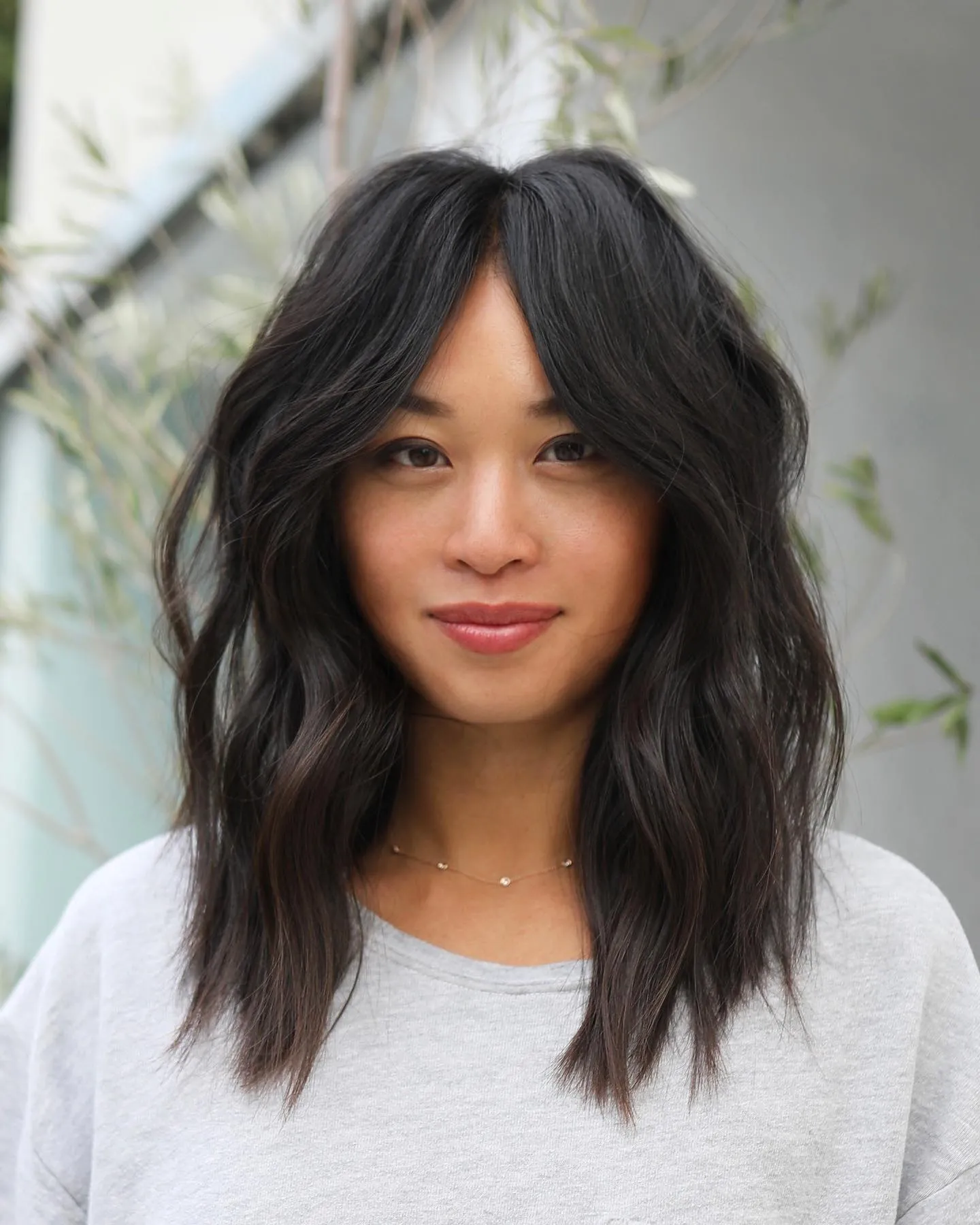 Centre-parted wavy lob with long curtain layers and textured shoulder-length ends