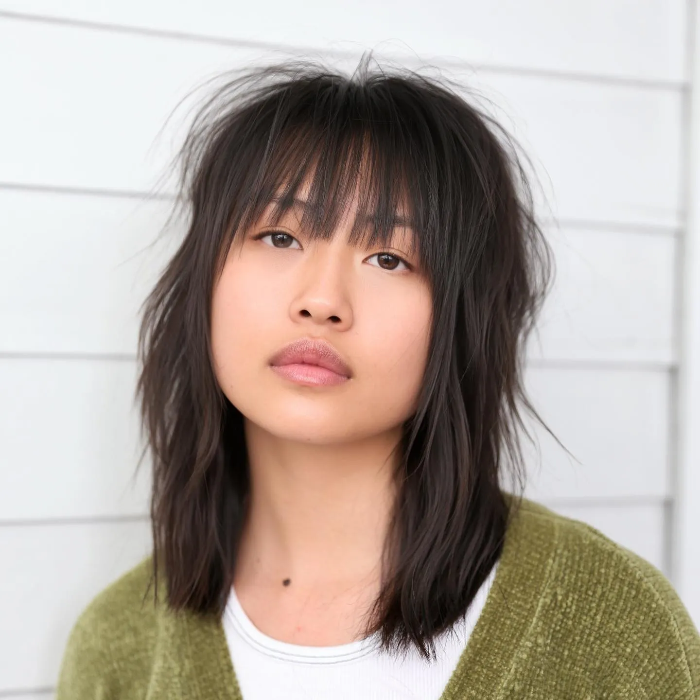 Choppy shoulder-length shag with wispy fringe and piecey face-framing layers