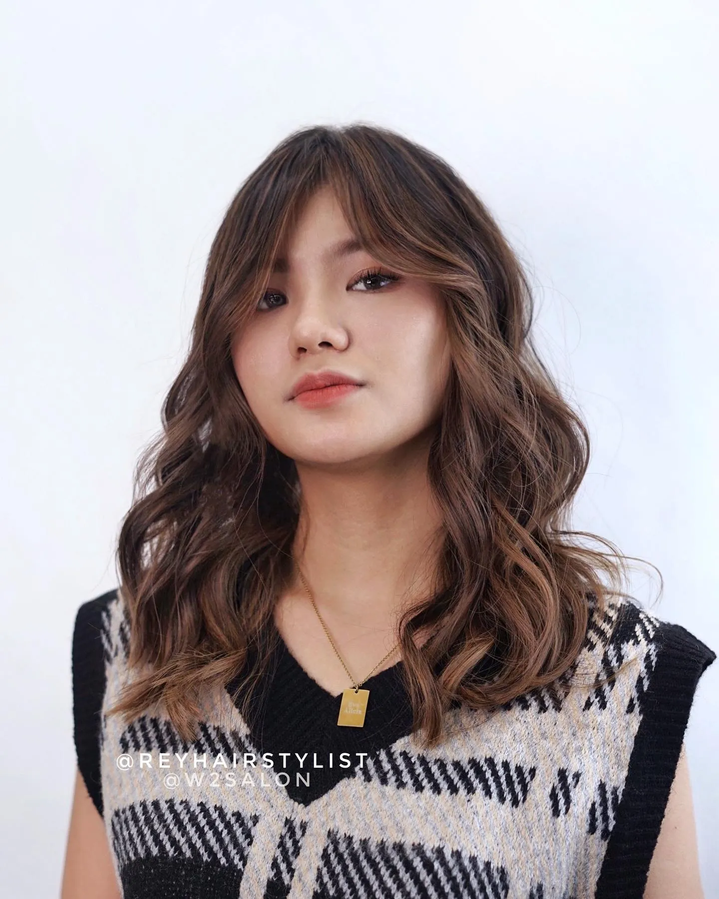 Wavy shoulder-length lob with soft curtain fringe and loose layered curls