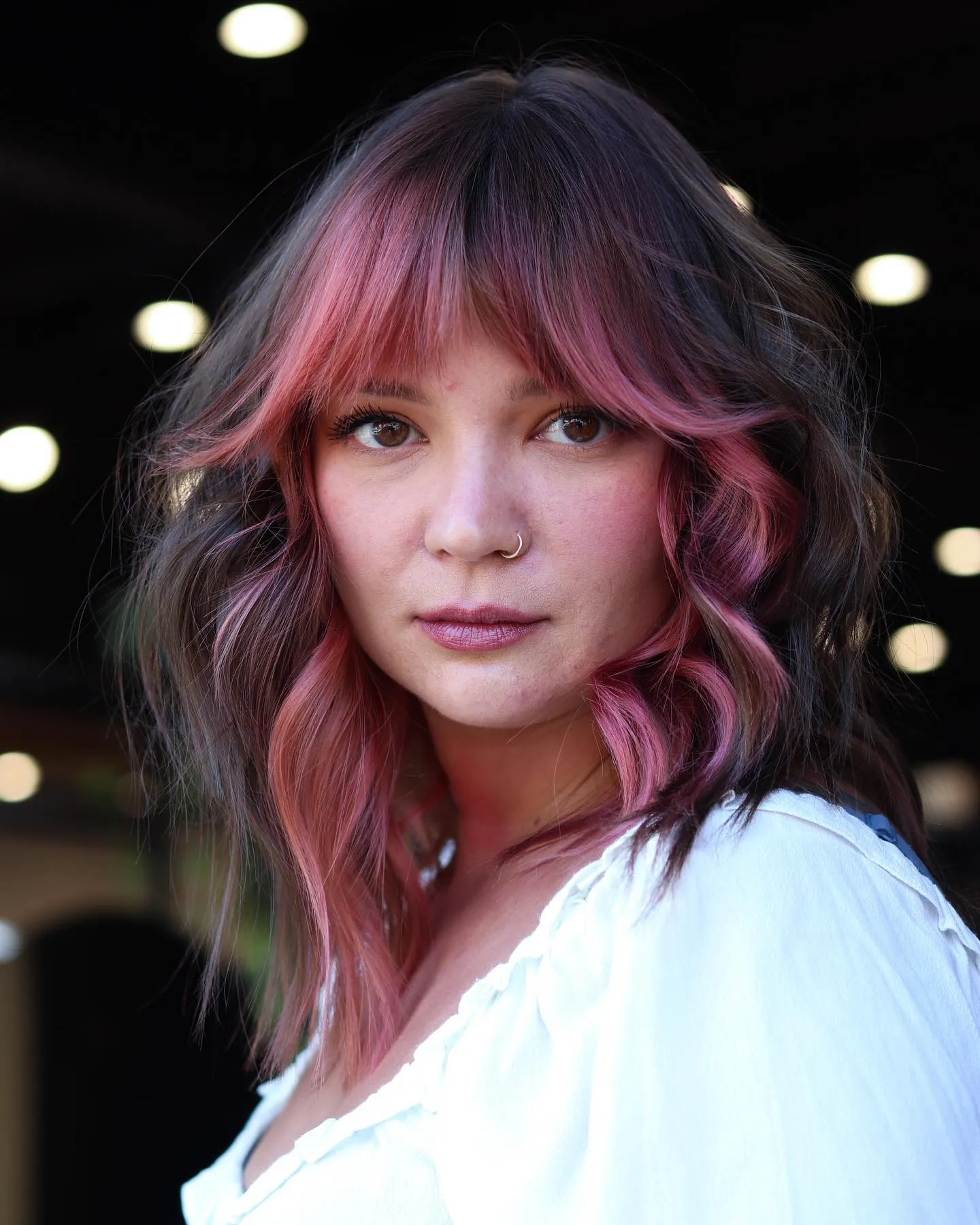 Wavy lob with rounded fringe, dark crown and pink face-framing colour