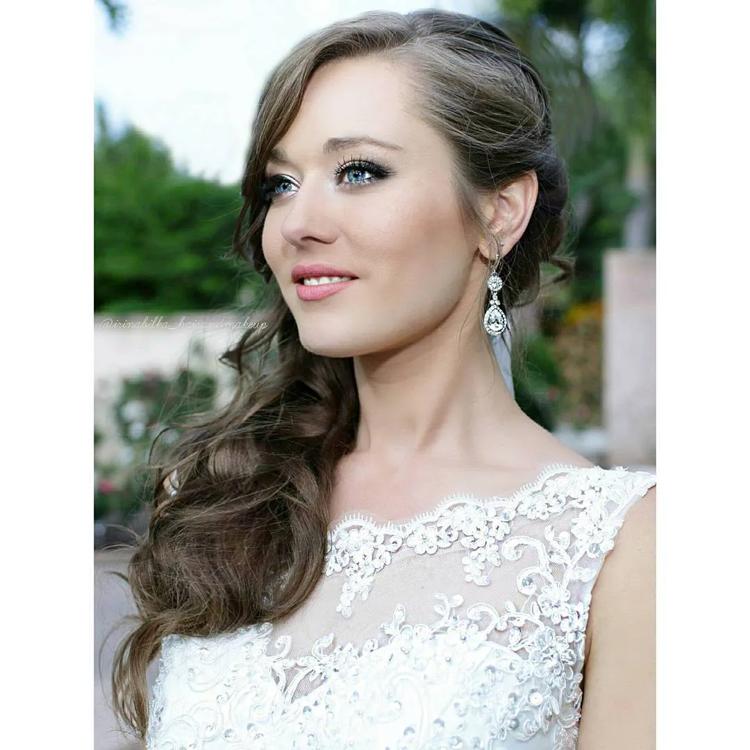 Long brunette bridal curls swept over one shoulder