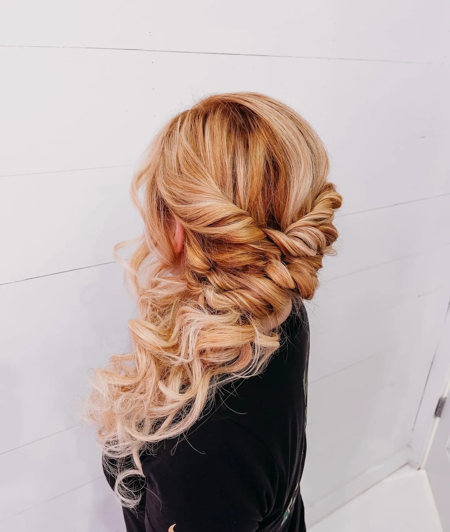 Twisted bridal half-up style with curls cascading to one side