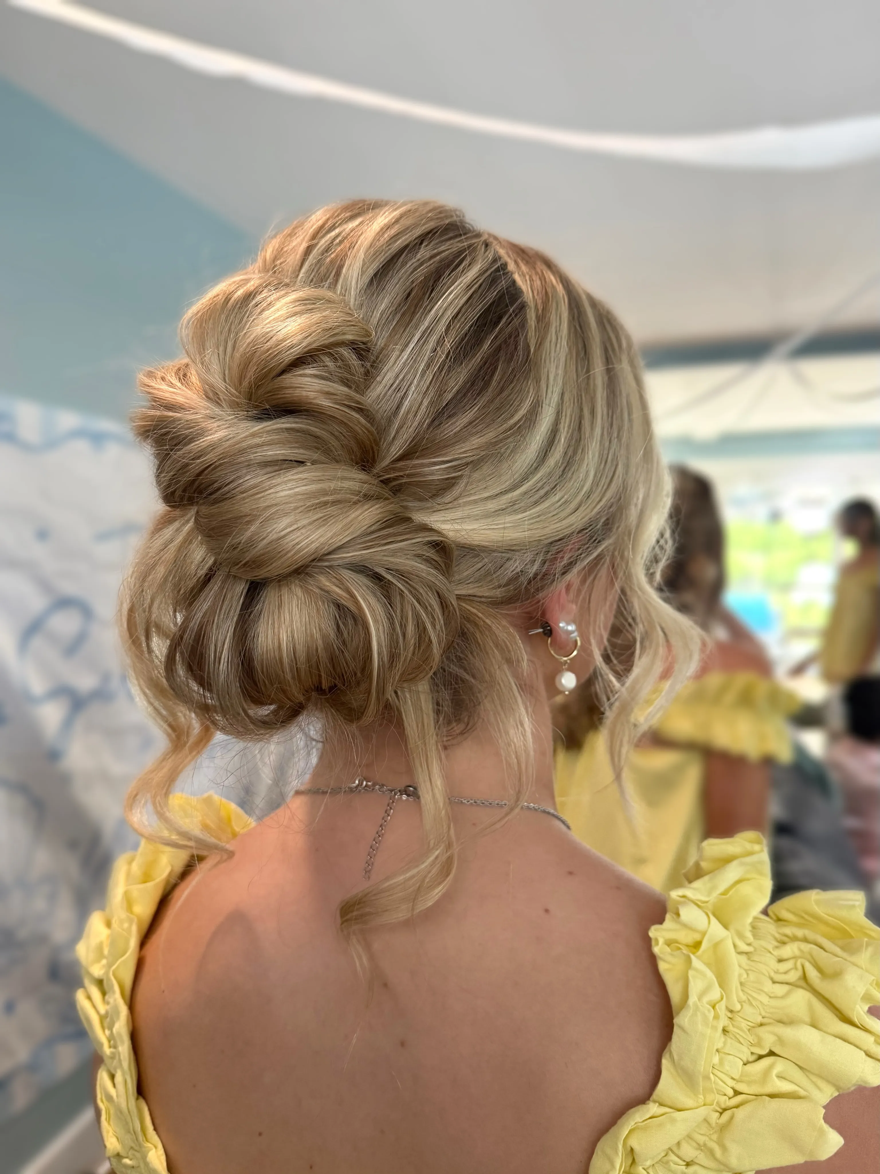 Blonde voluminous bridal low bun with soft twisted sections