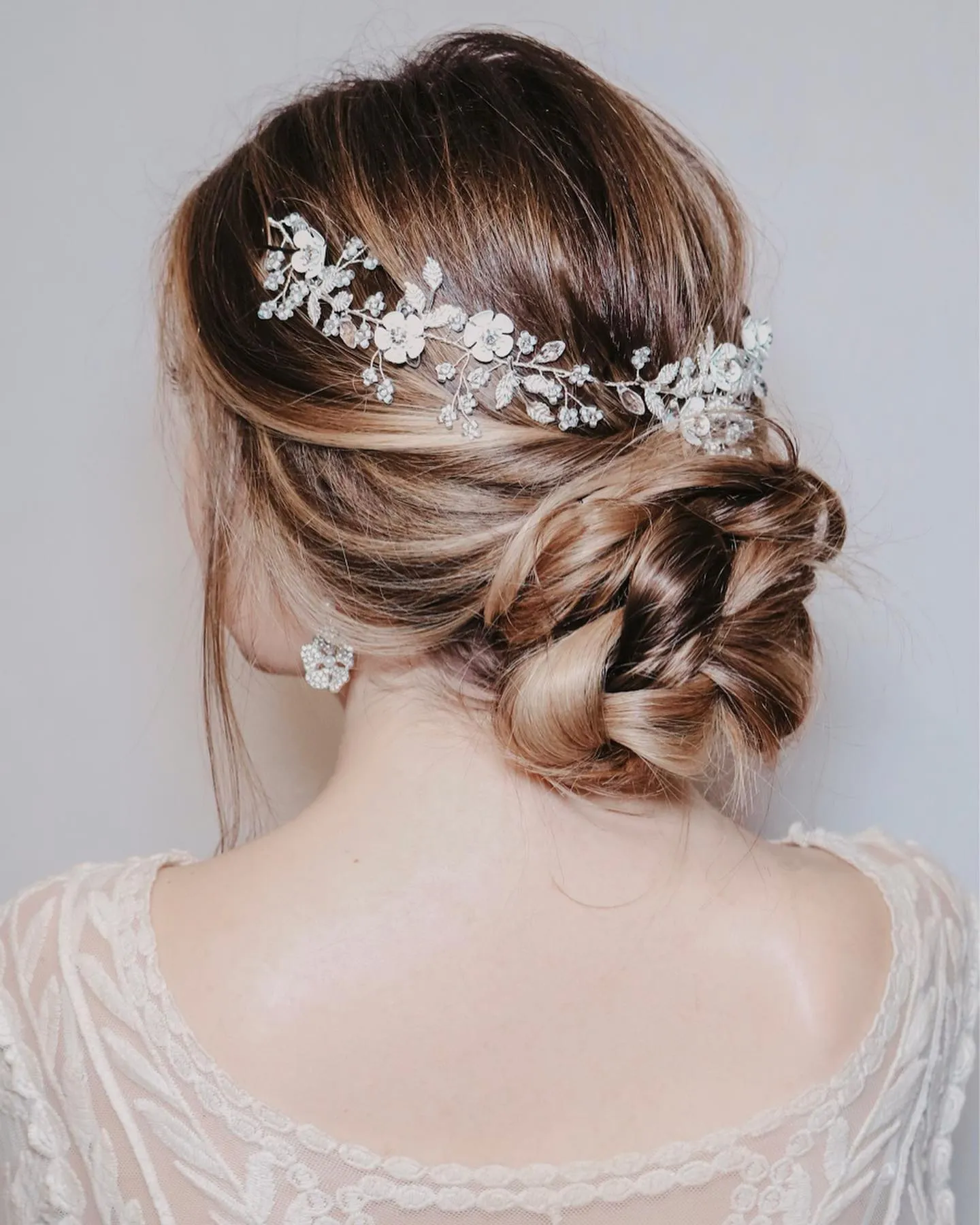 Brunette twisted bridal bun with a silver crystal vine accessory