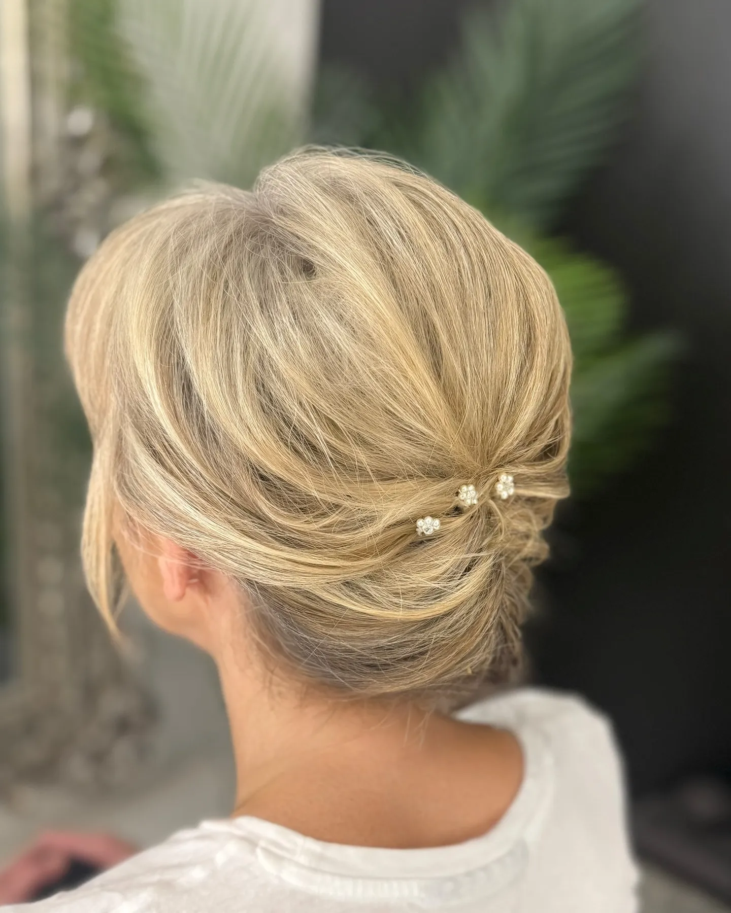 Soft blonde twisted bridal chignon with delicate crystal pins