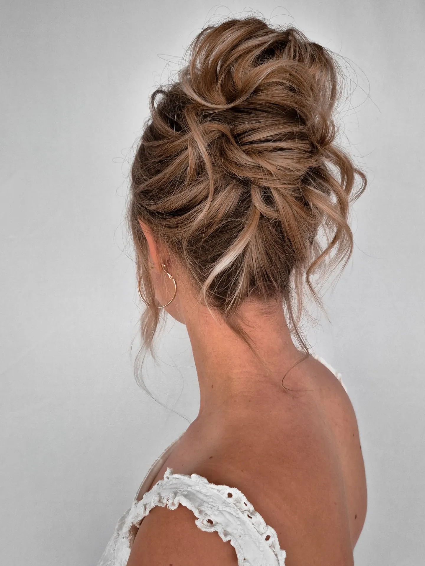 Brunette airy bridal high updo with loose textured loops