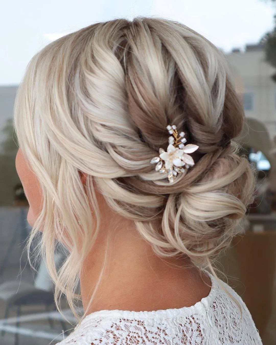 Blonde side bridal bun with a sparkling floral hair accessory