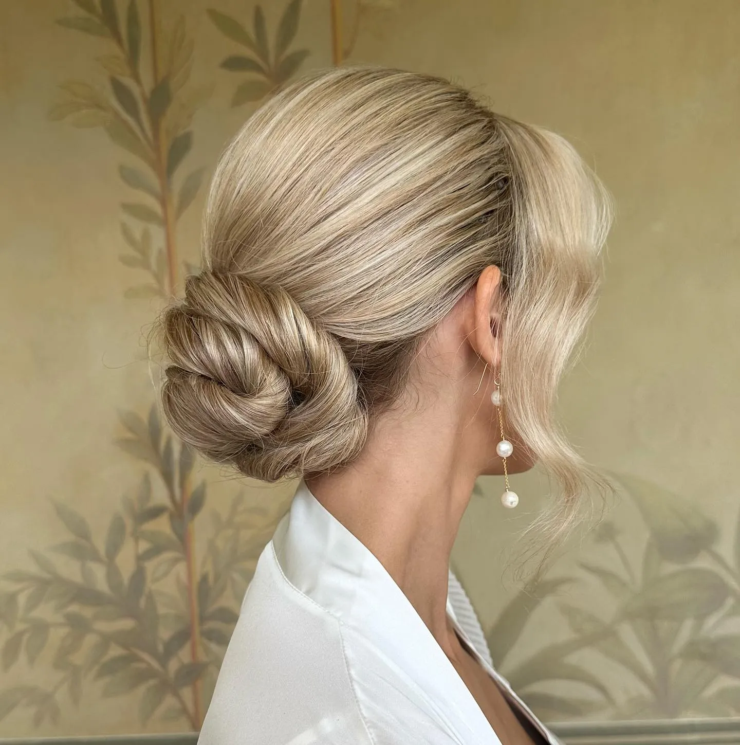 Sleek blonde bridal bun with a compact knotted shape