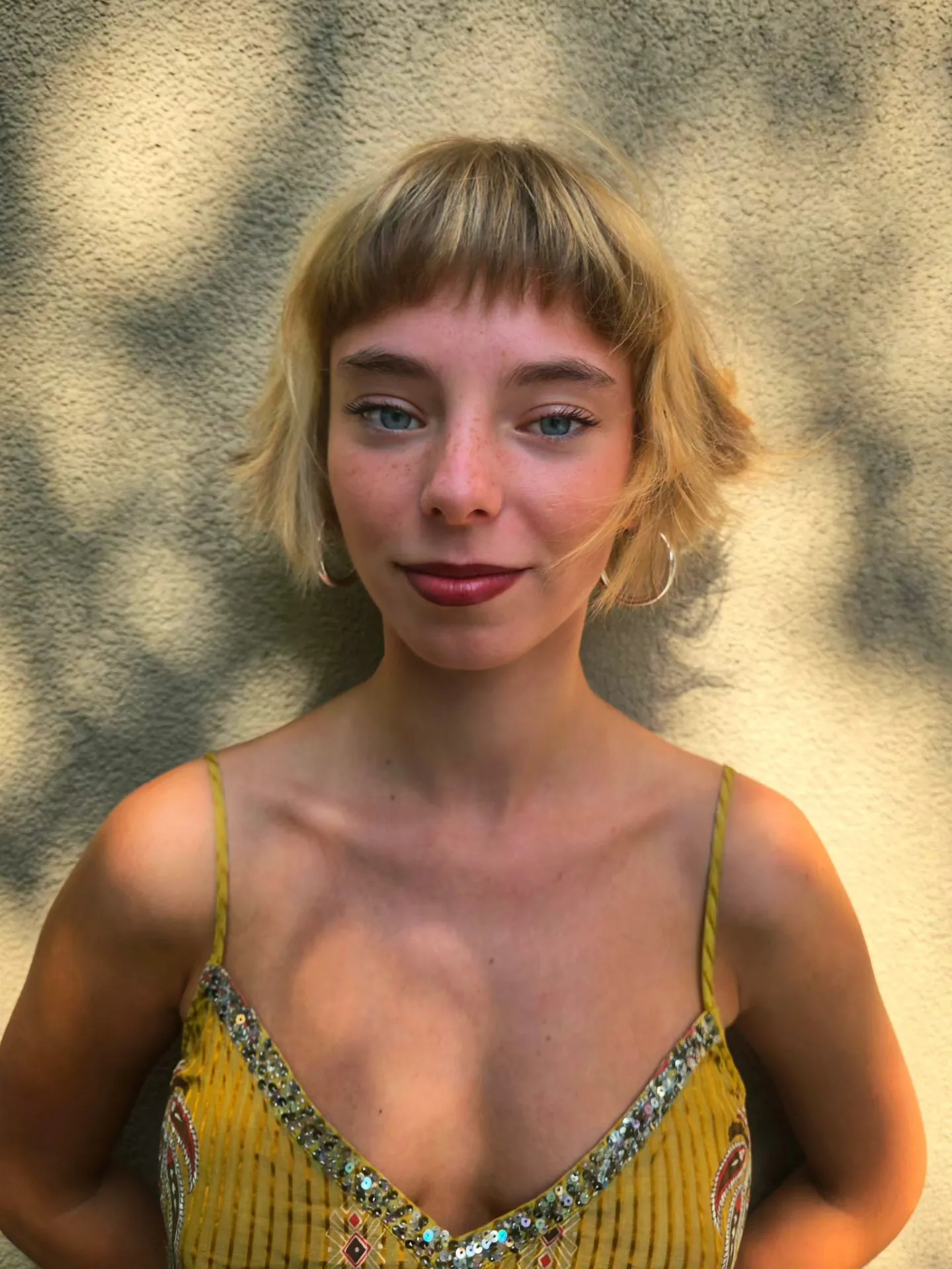 Short blonde bob with a micro fringe and flipped-out ends