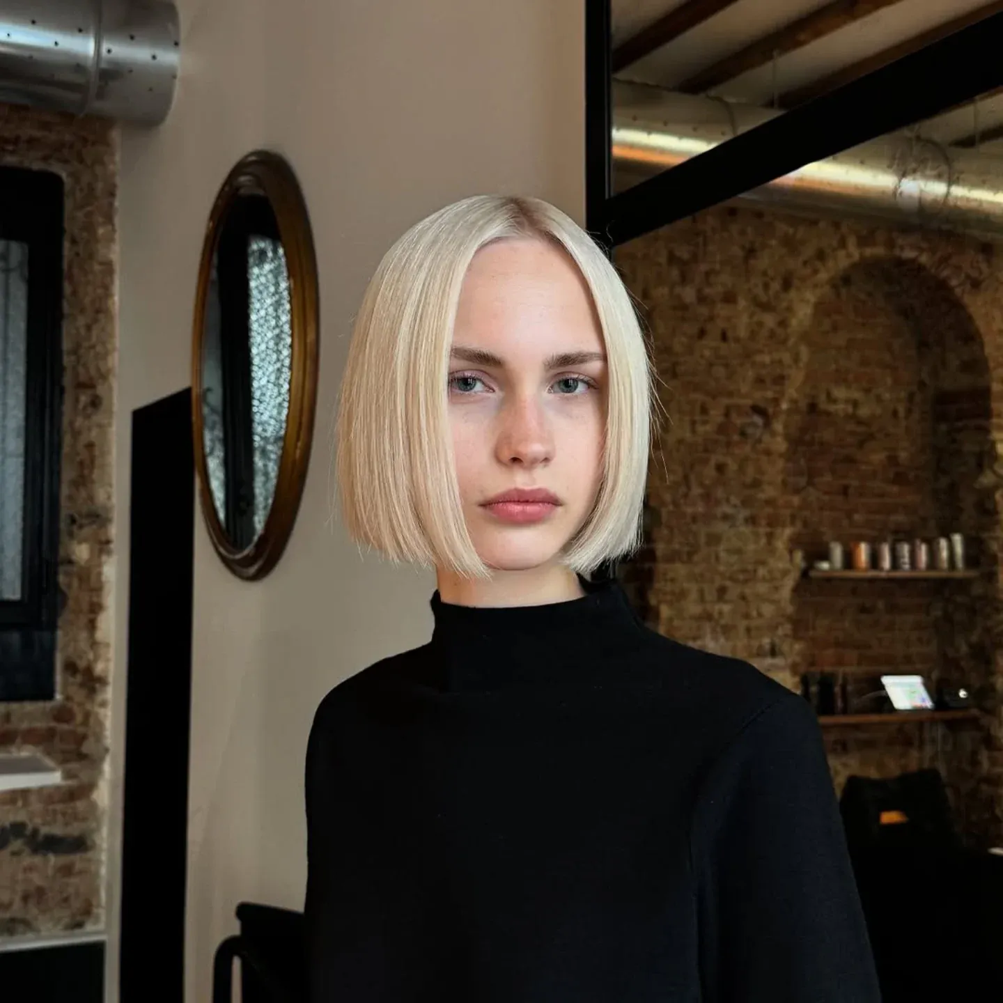 Sleek pale blonde chin-length bob with a precise center part