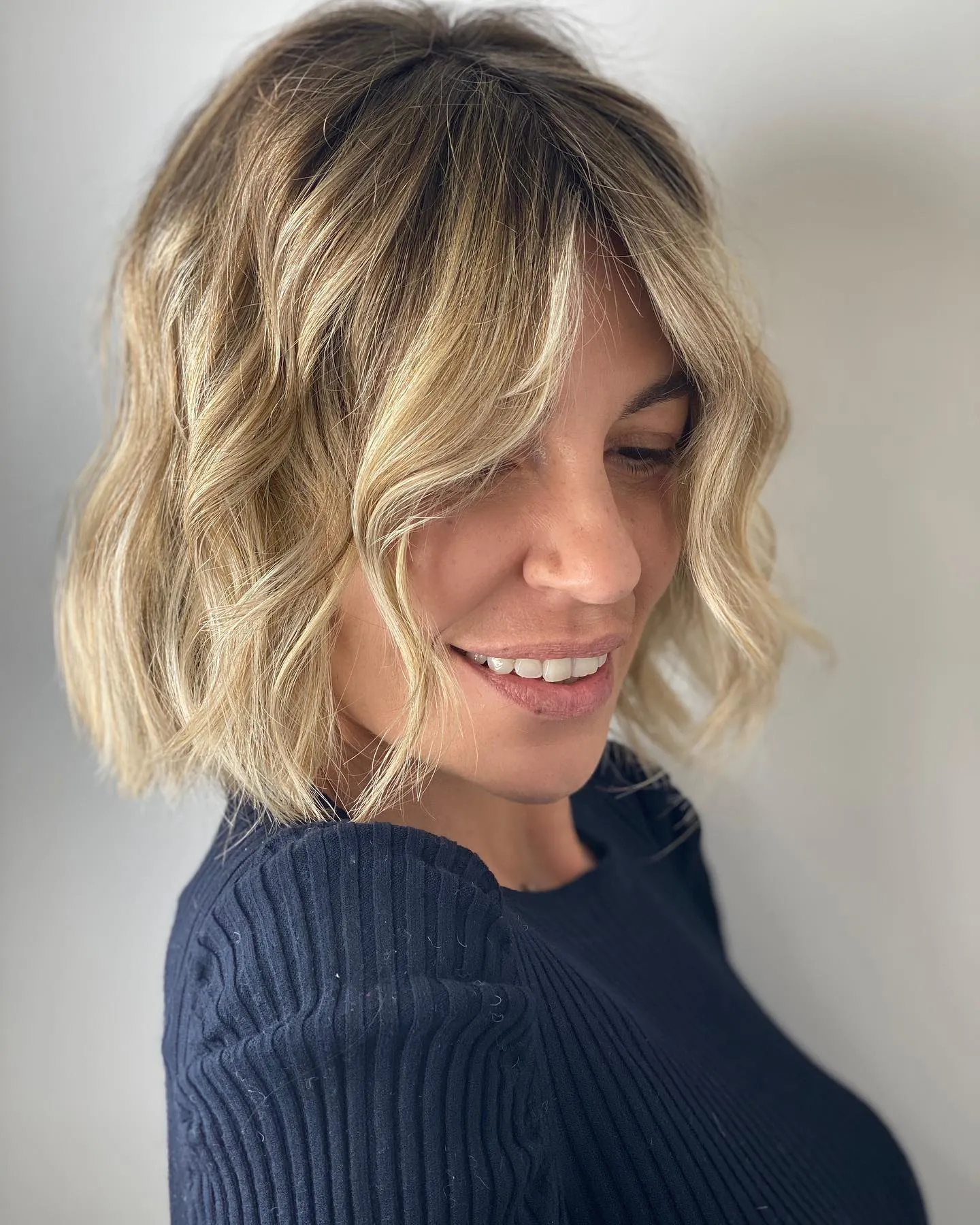 Blonde blunt bob with loose waves and soft face framing