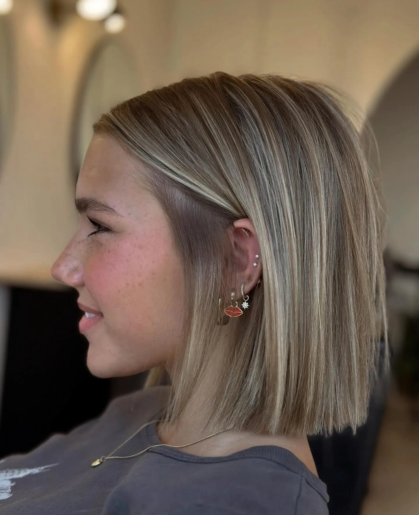 Straight blonde blunt bob with the front section tucked behind the ear