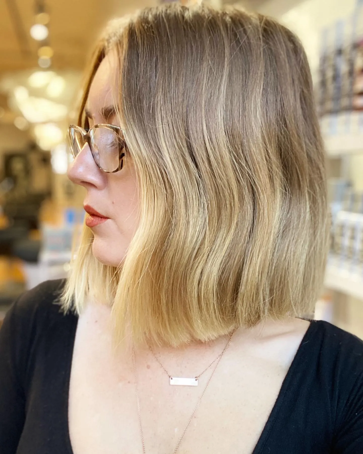 Long blonde blunt bob with a center part and soft bend