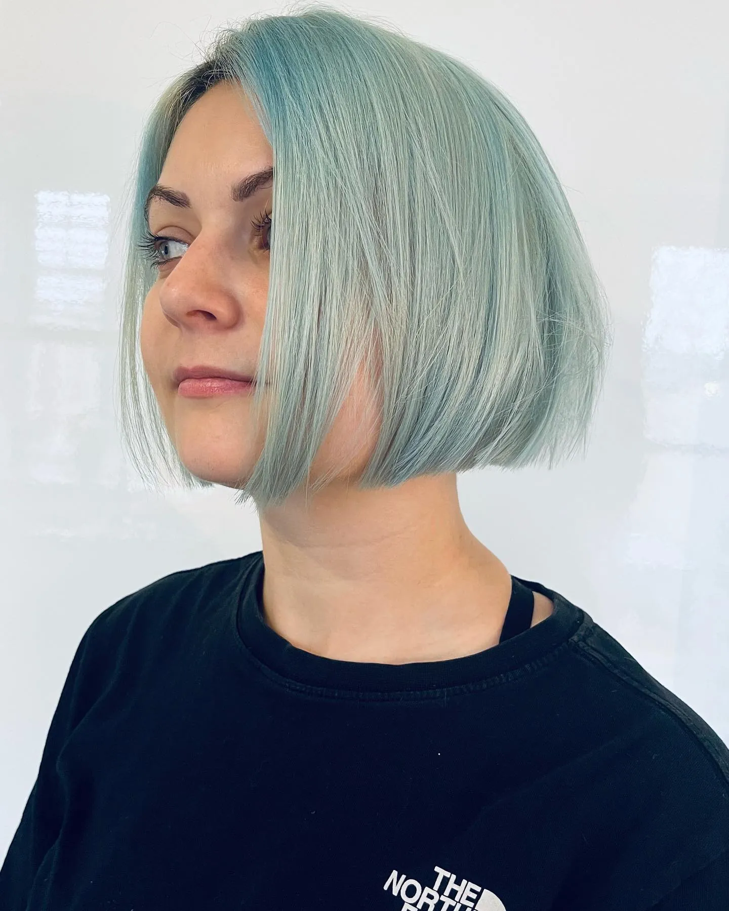 Sleek aqua chin-length bob with a smooth blunt perimeter