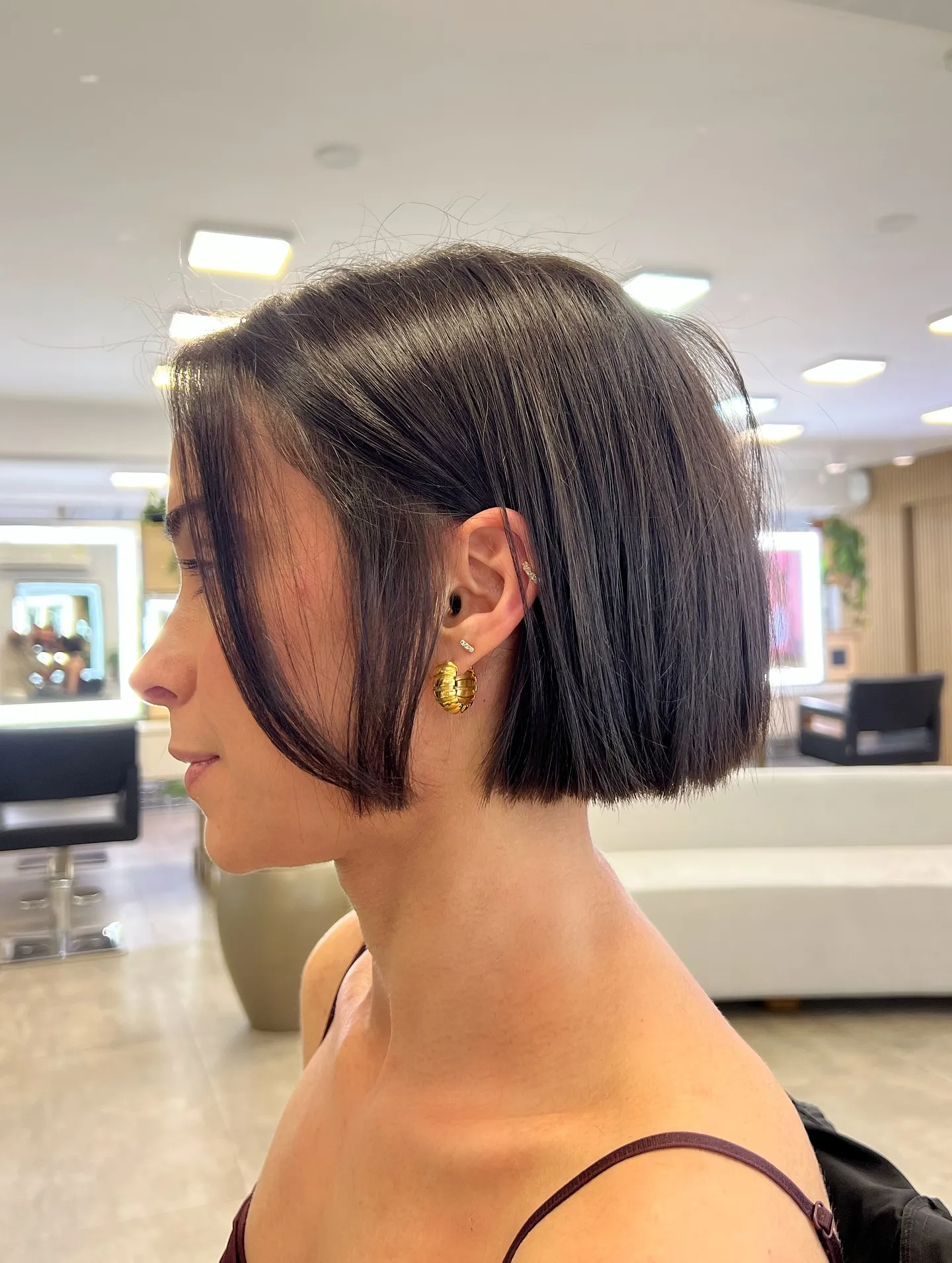 Dark straight micro bob tucked behind the ear with longer front pieces
