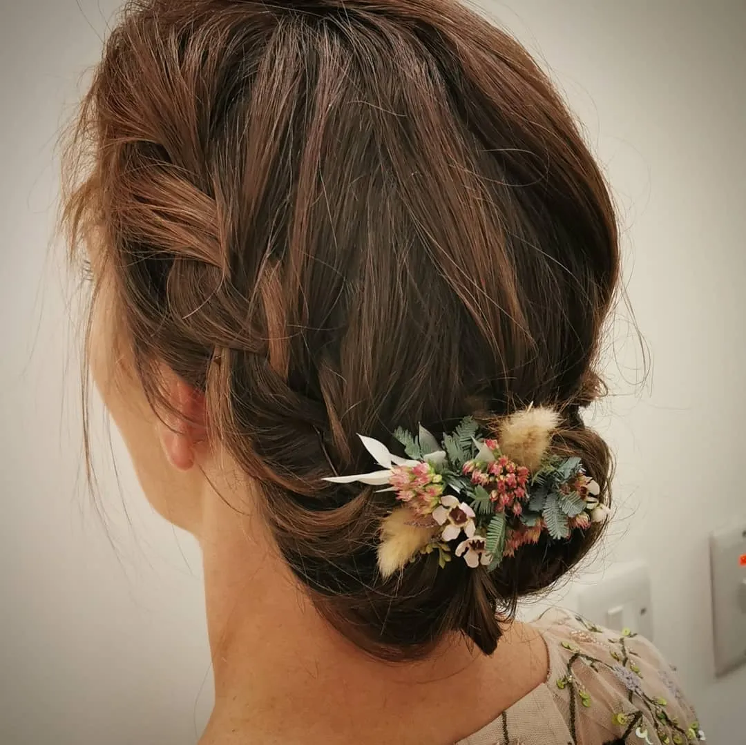 Low rolled updo for short brown hair with a dried flower comb