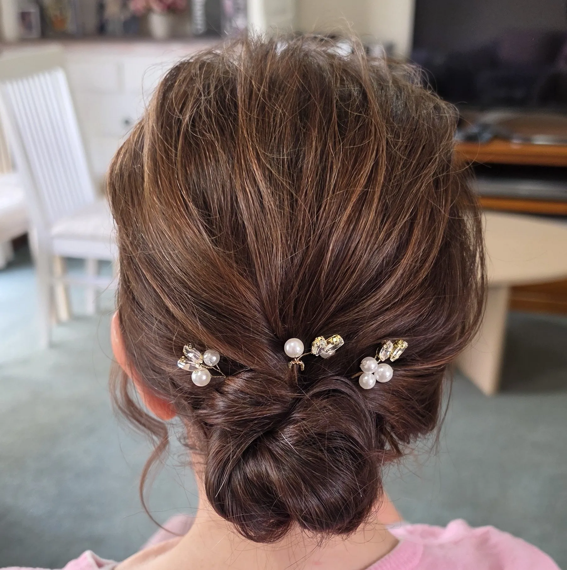 Low knot wedding updo for short brown hair with pearl pins